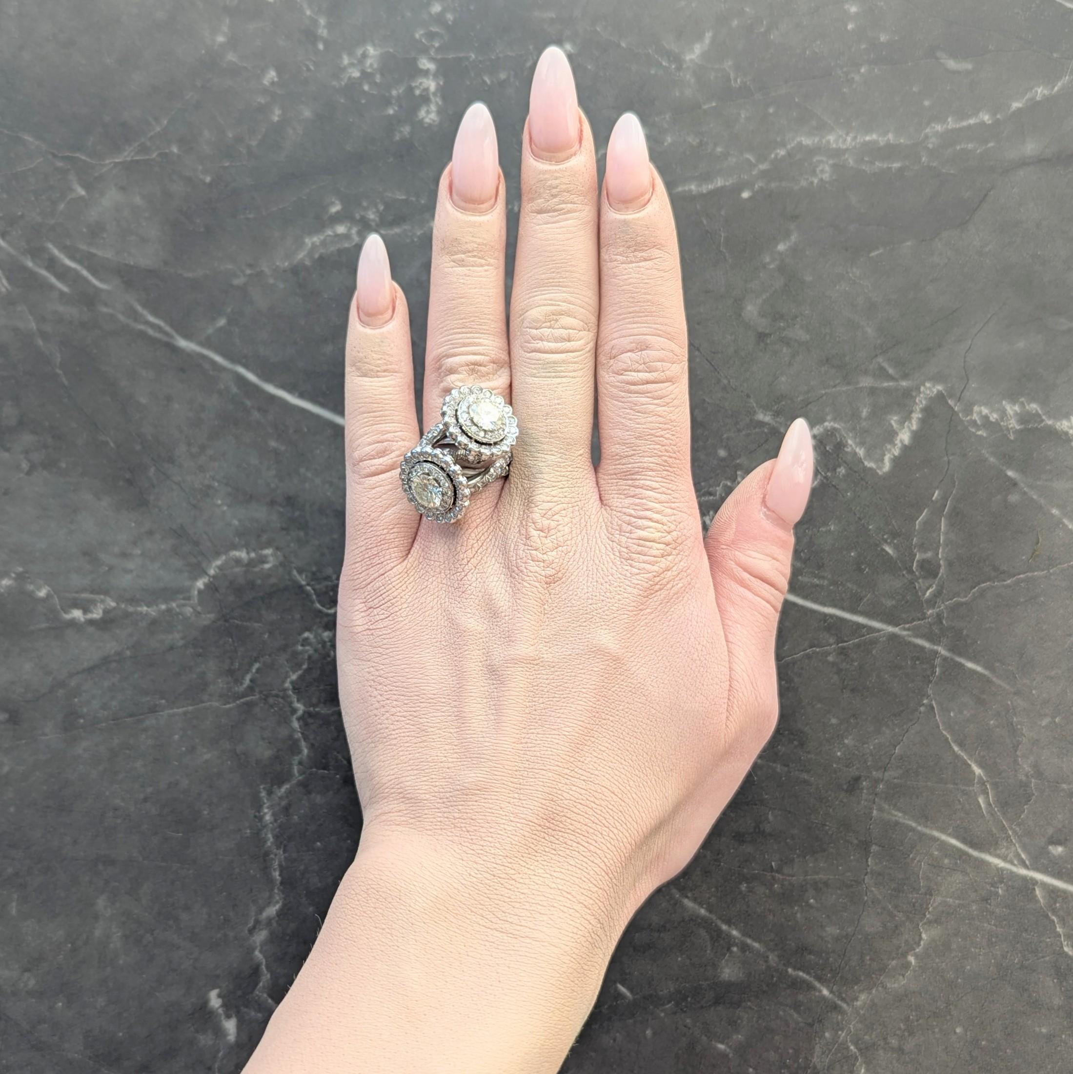 Designed as a coiled bypass style band terminating with diamond halos with wire galleries
Centering prong set transitional cut diamonds - O-P in color 
Weighing approximately 1.70 and 1.45 carats, respectively - with VS2 clarity
Halos are bead set