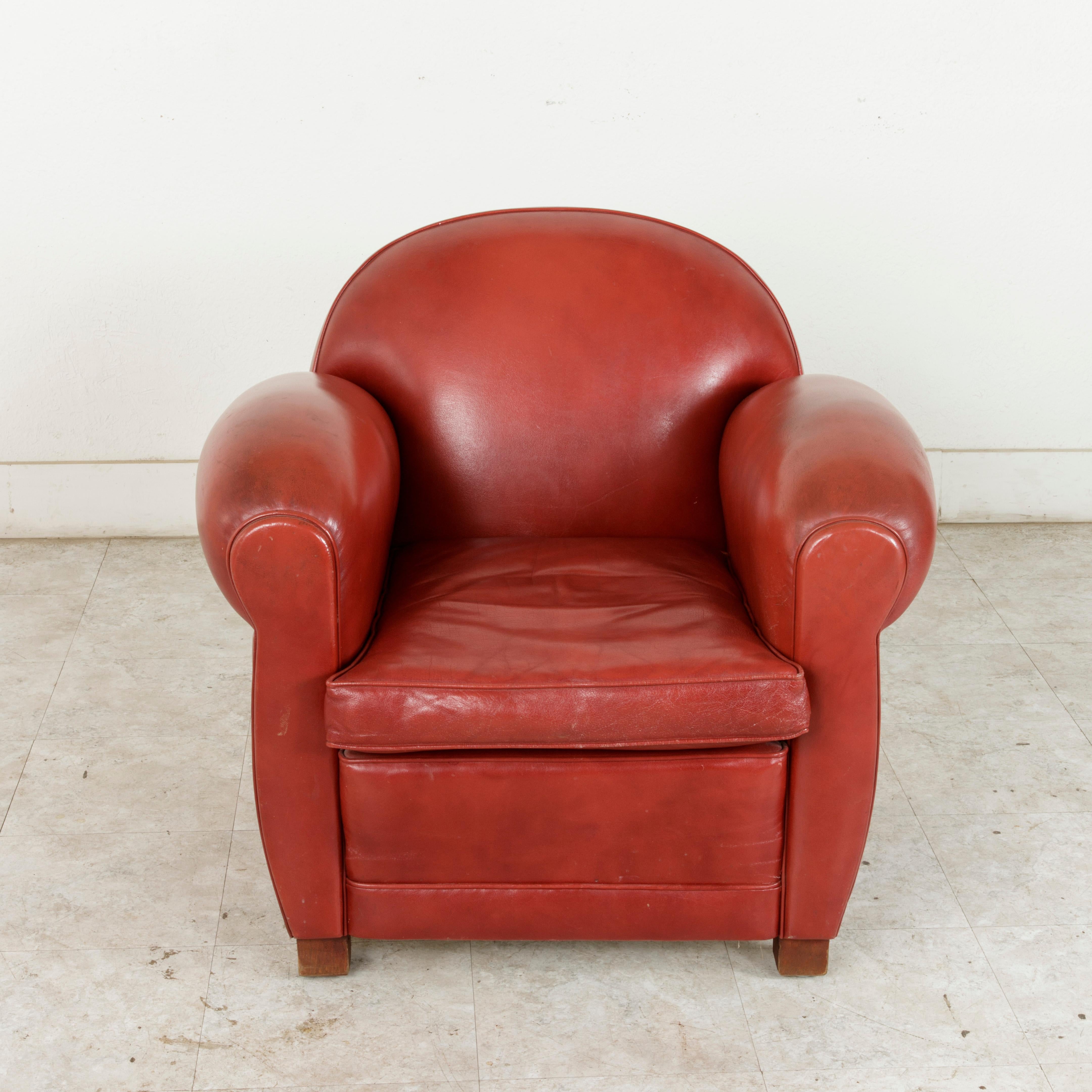 This mid-20th century French club chair or lounge chair boasts the Classic lines of the 1950s French Art Deco style. In wonderful condition, its original red leather upholstery is smooth to the touch, making this club chair comfortable as well as