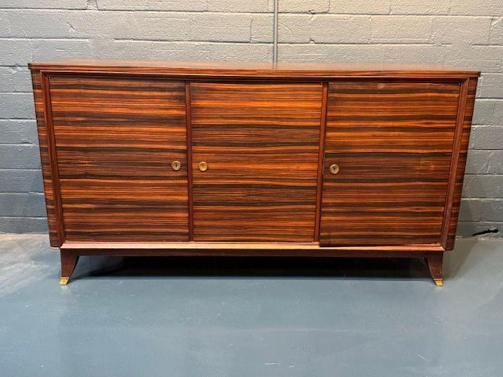 Realizzato con un occhio di riguardo per l'eleganza senza tempo, questo buffet di Macassar in stile Art Deco francese del Mid Century fonde senza sforzo il design classico con la funzionalità moderna. Ideale per chi apprezza il fascino delle epoche