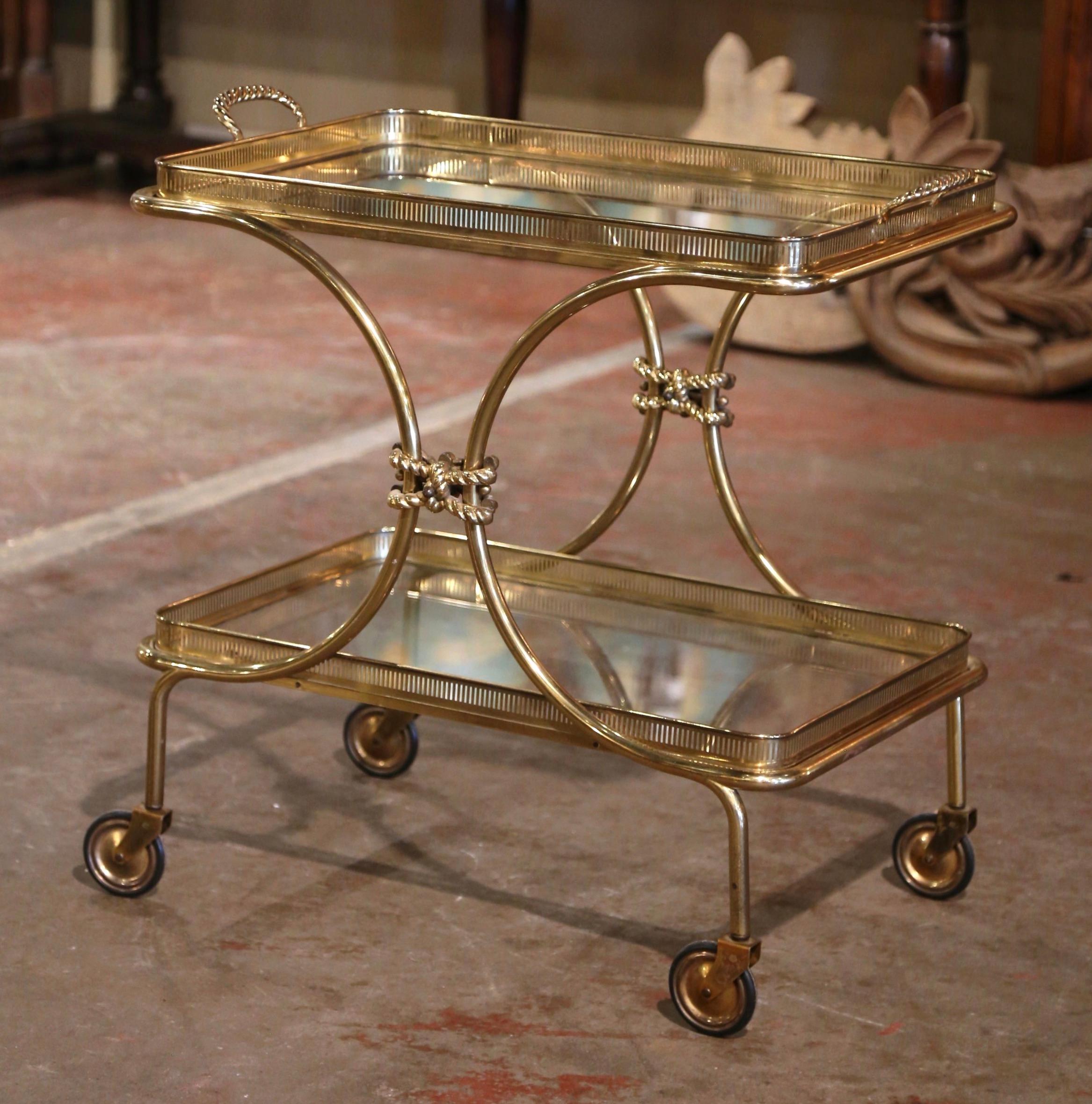 This elegant, vintage rolling bar cart was created in France, circa 1930 and attributed to Maison Bagues. The rectangular dessert table has a brass frame, small wheels with rubber tires over short straight legs, and two rectangular shelf plateaus