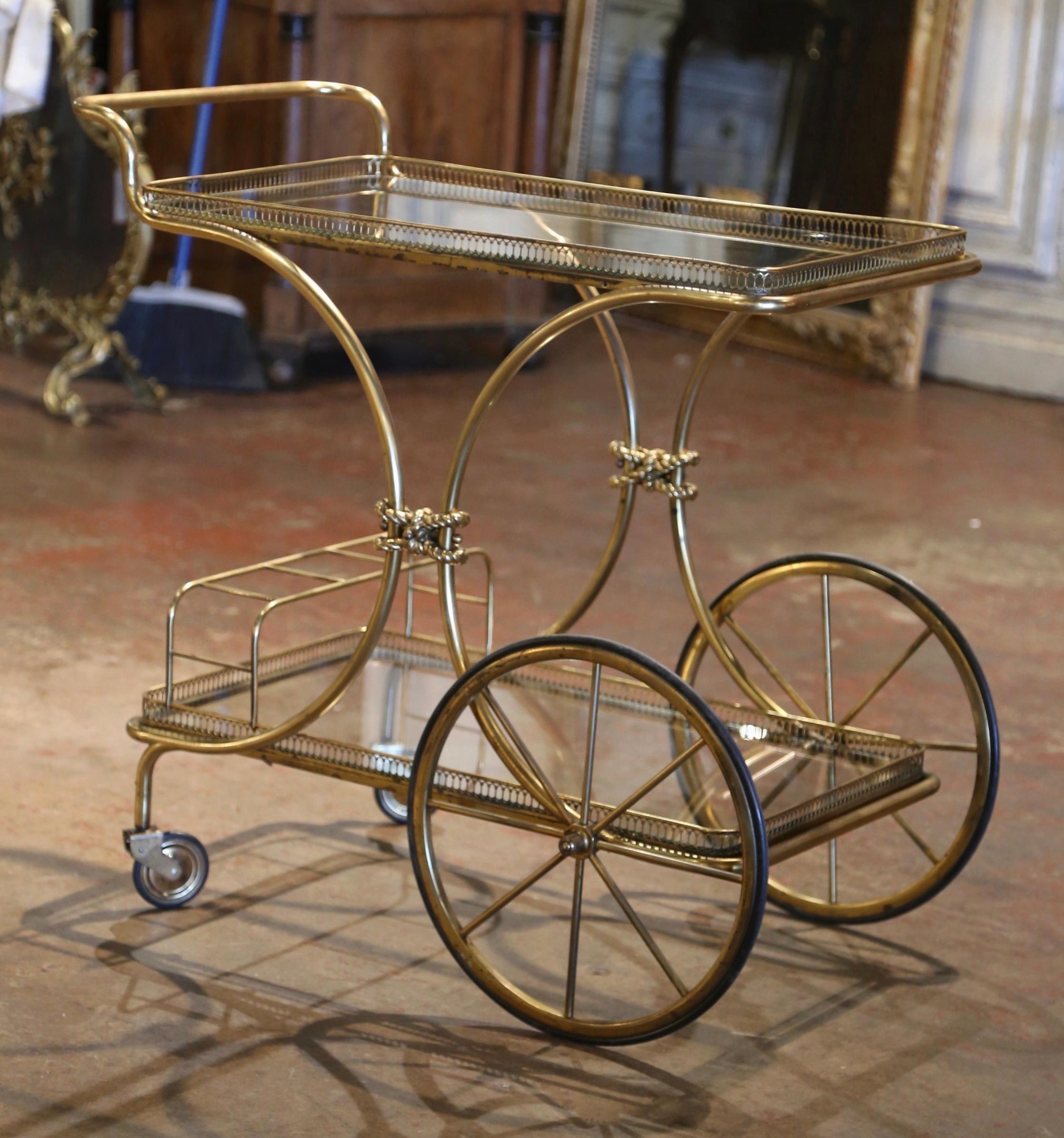 This elegant, vintage rolling bar cart was created in France, circa 1930 and attributed to Maison Bagues. The rectangular dessert table has a brass frame, large front spoked wheels, two swivel caster wheels all with rubber tires, and two rectangular