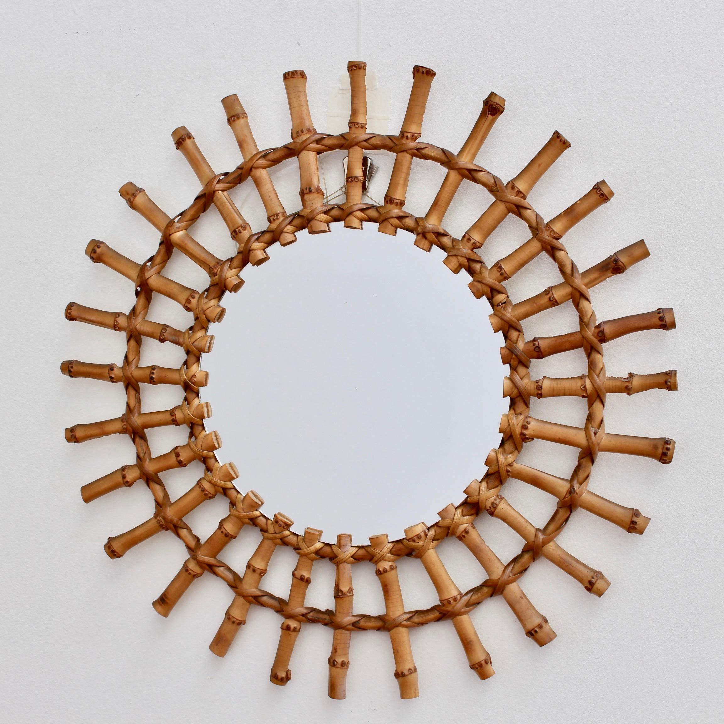 Midcentury French bamboo sunburst mirror (circa 1960s) with classic features and a charming aged patina making this very collectible. The mirror is in very good vintage condition consistent with its age and use. Upon request a video of the piece