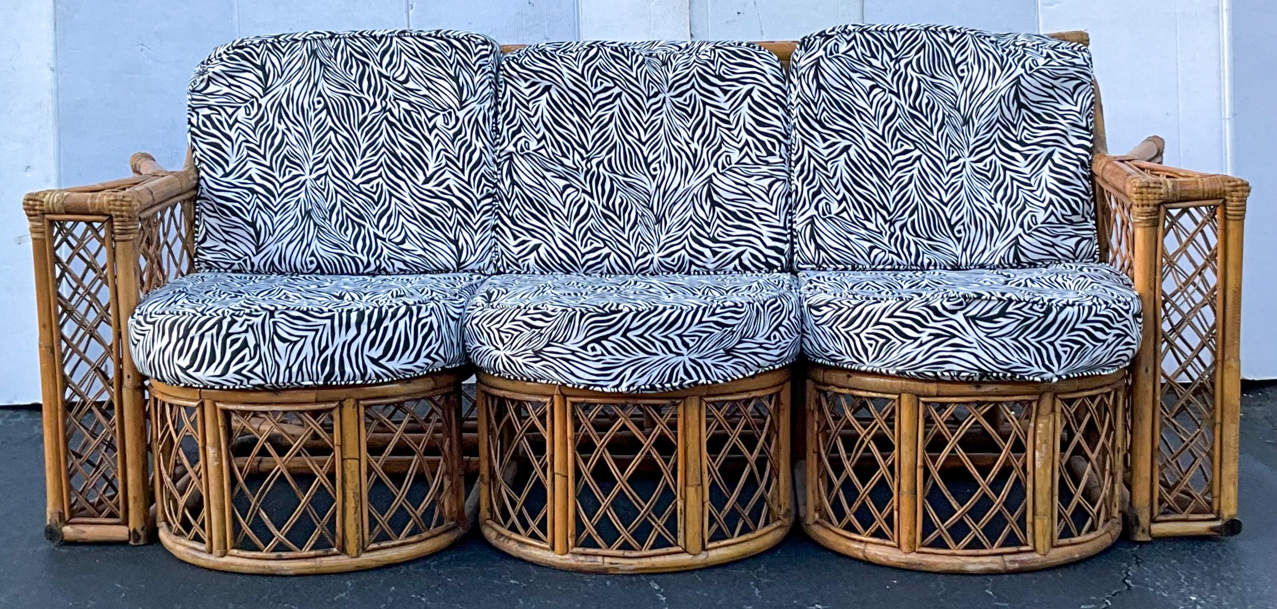 This is a mid-century French bent bamboo sofa in very good condition. The upholstery is a printed zebra cotton. It dates to the 1960s. Discounts will be given for purchasing multiple pieces.