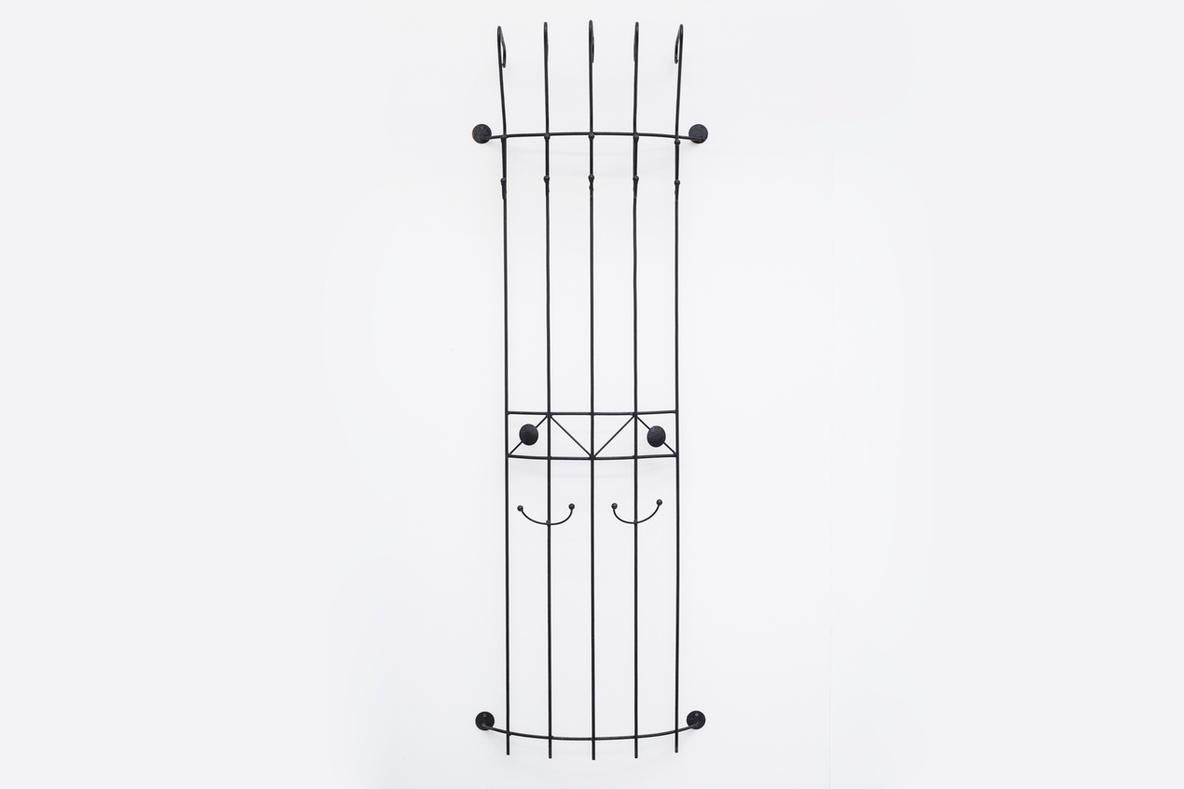 Porte-manteau mural en métal émaillé noir avec crochets hauts pour chapeaux. En état d'origine avec des signes visibles d'usure.