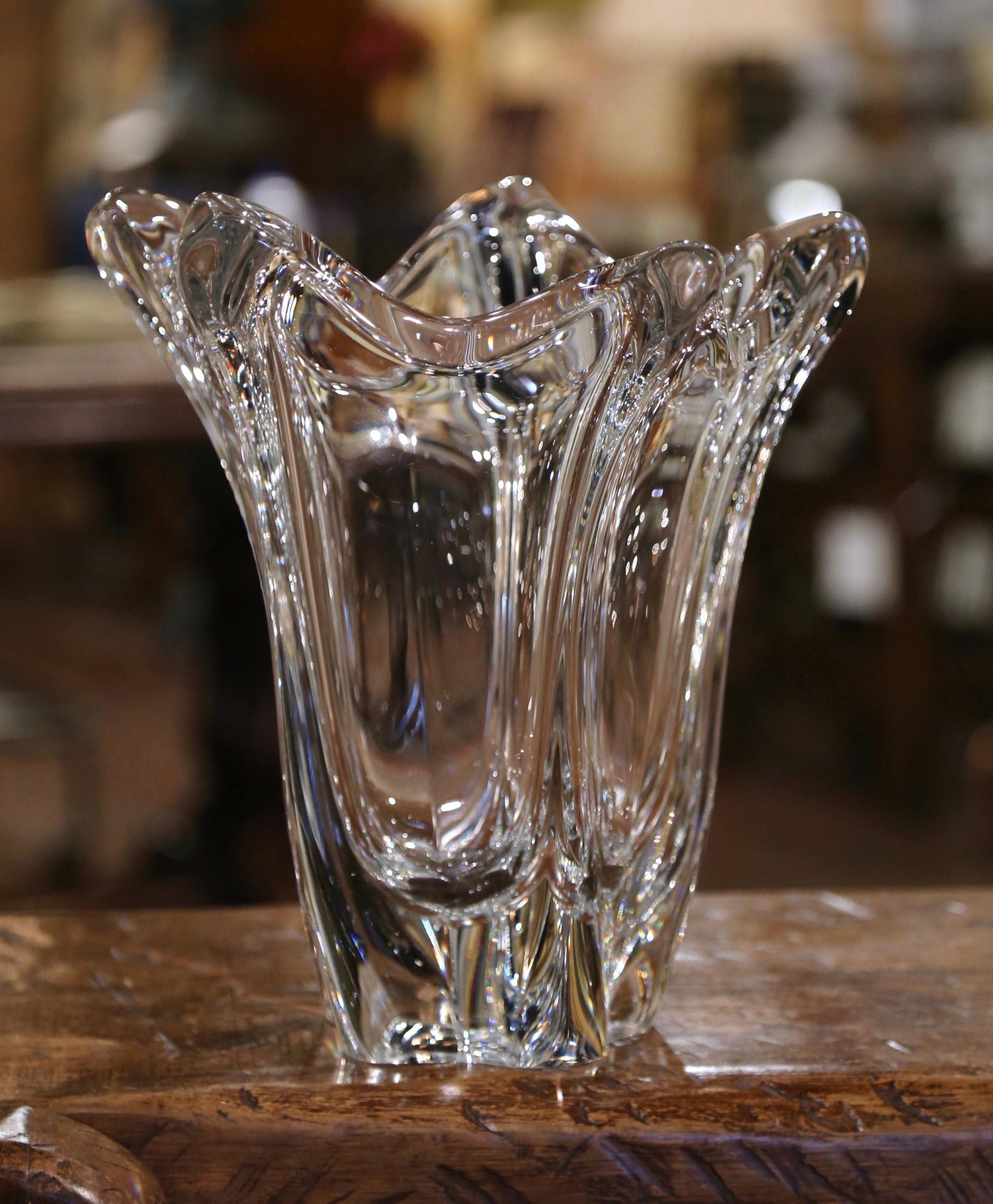 This elegant, hand blown crystal art vase was crafted in France, circa 1950. The large antique piece features a pulled feathered technique with an intricate elongated design and scalloped rim. The large decorative flower recipient is in excellent
