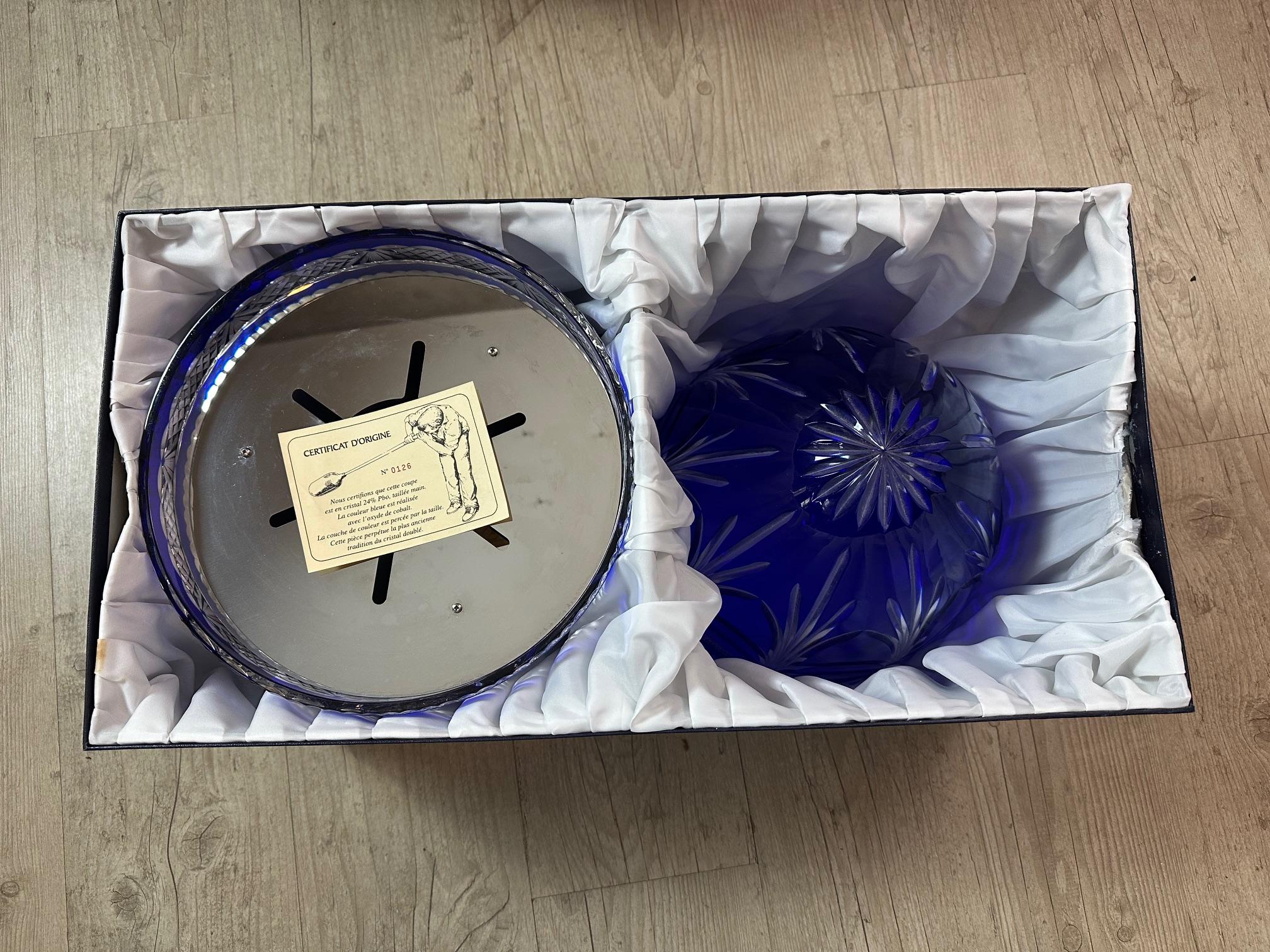 Blue crystal champagne cellar in the shape of an egg opening in the middle and showing a chromed metal part inside to be able to place 6 champagne glaces and a bottle of champagne in the center on a bed of ice. 
Dating from the 50s, this egg is in