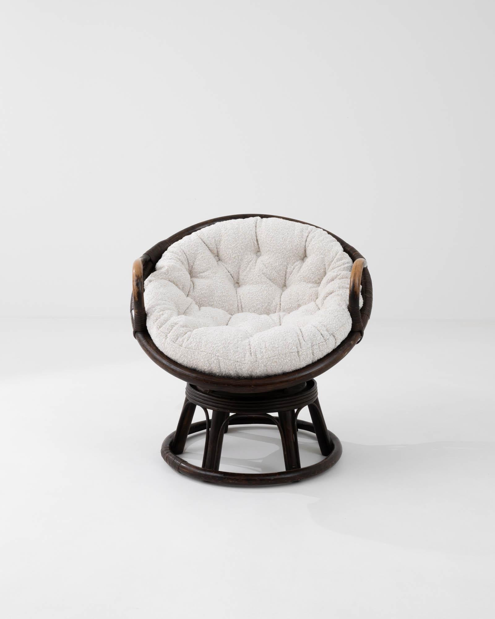 Made in France in the mid-20th century, this rattan frame lounge chair is topped with a soft bouclé cushion. Rotating for added comfort, this chair rests the sitter in a low recline for ultimate comfort. A rich brown finish heightens the sense of