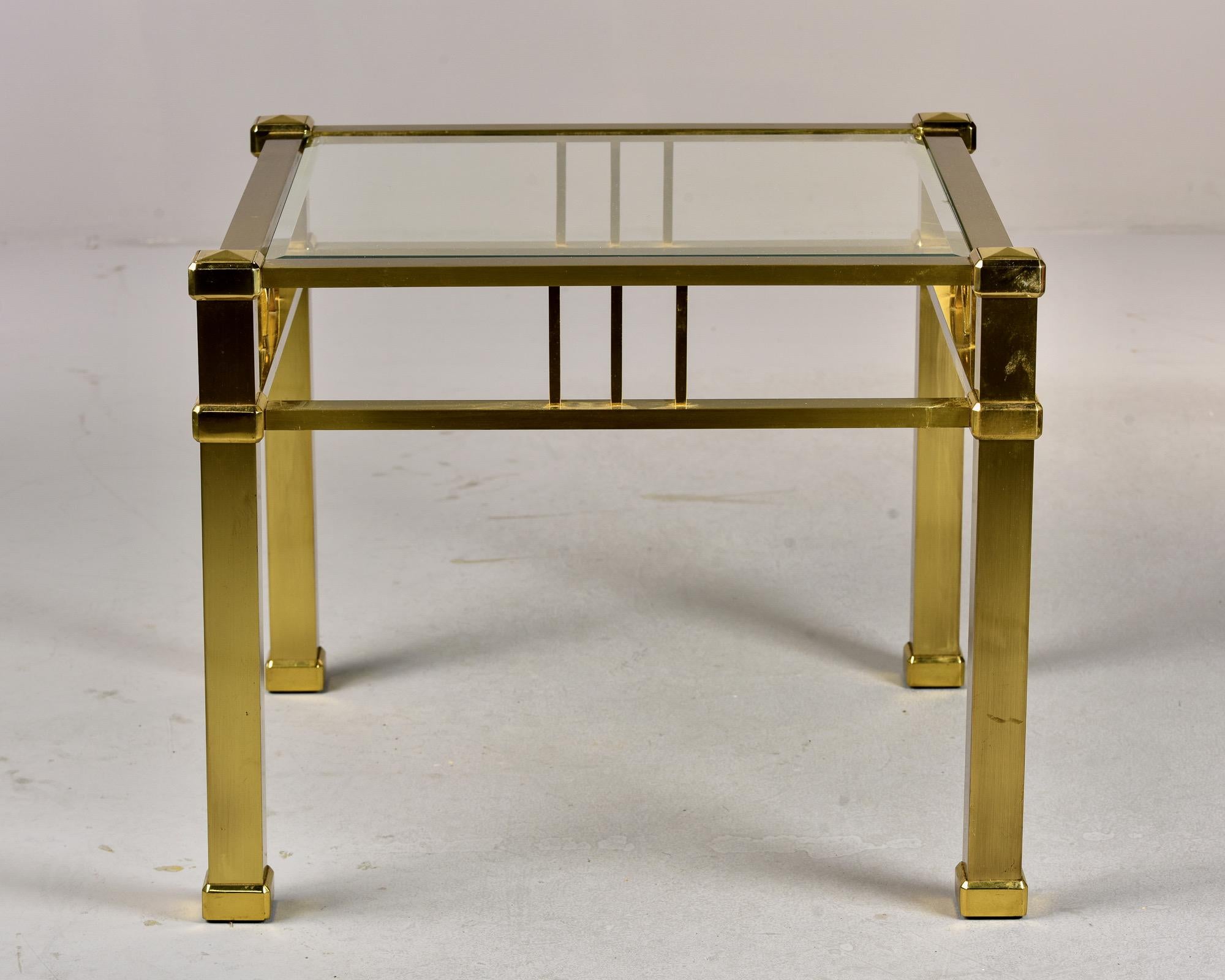 Circa 1970s French cocktail table made of solid brass with a glass top. Unknown maker. Very good vintage condition with some patina and surface wear.