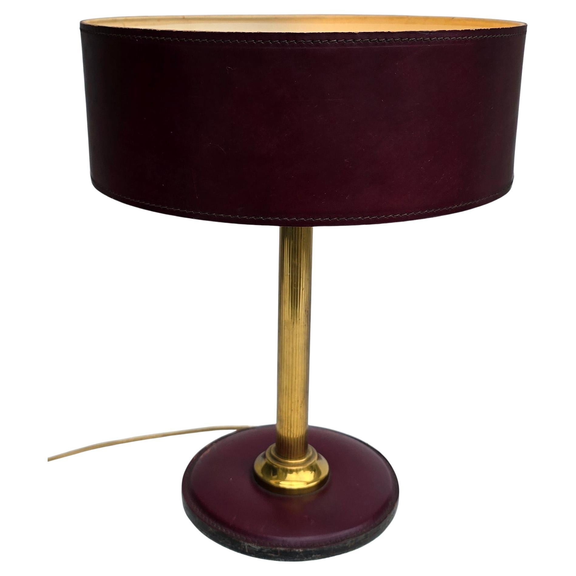 Lámpara de sobremesa de cuero y latón de mediados de siglo - Al estilo de Delvaux, Hermès y Jacques Adnet

Elegante lámpara de sobremesa de mediados de siglo, de los años 50-60, fabricada en cuero burdeos oscuro con finas costuras y tija de latón