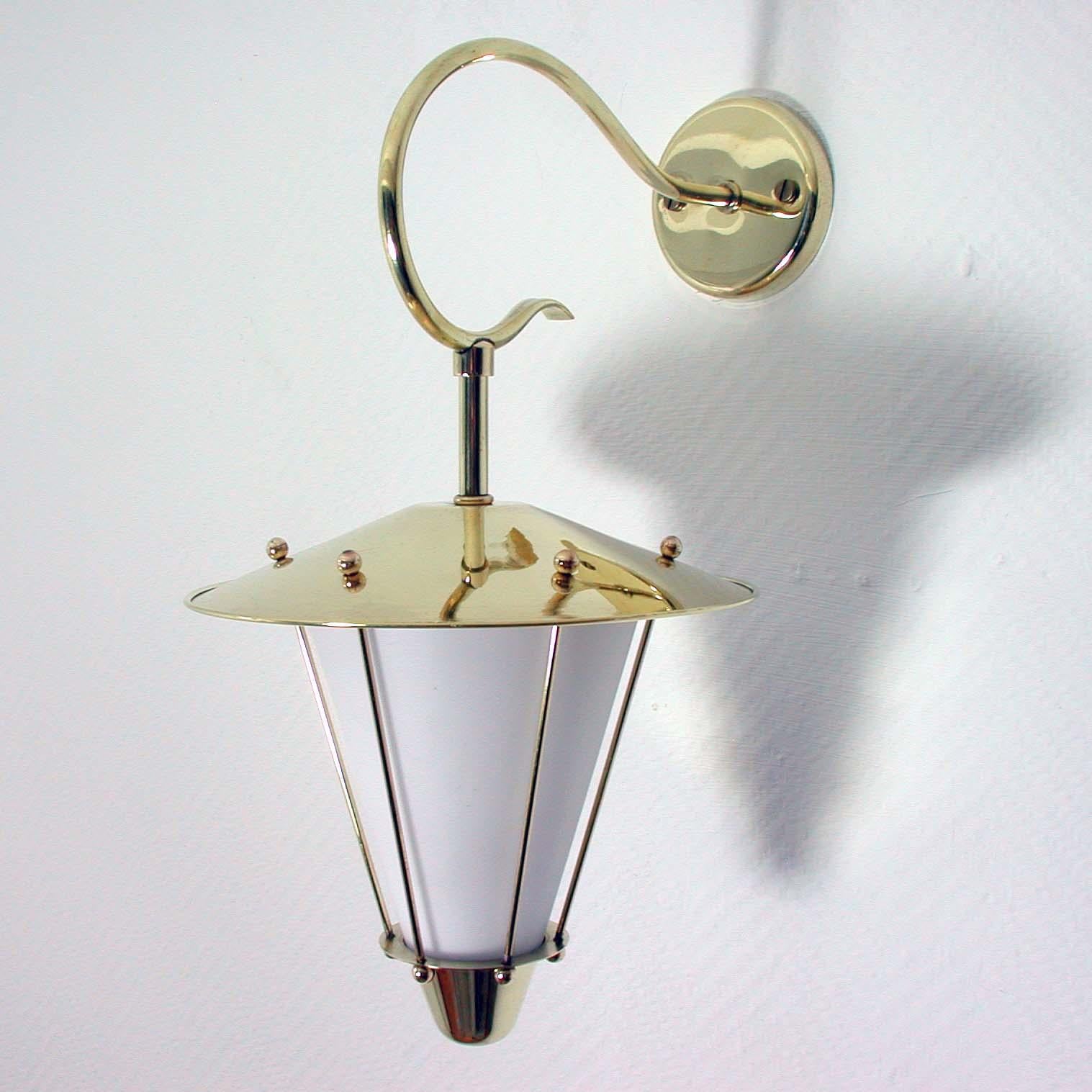 This elegant 1950s midcentury wall lamp / light fixture was designed and manufactured in France in the style of Maison Lunel.

The wall light is made of brass and has got a white opaline lamp shade. The lamp has been rewired. This light can be