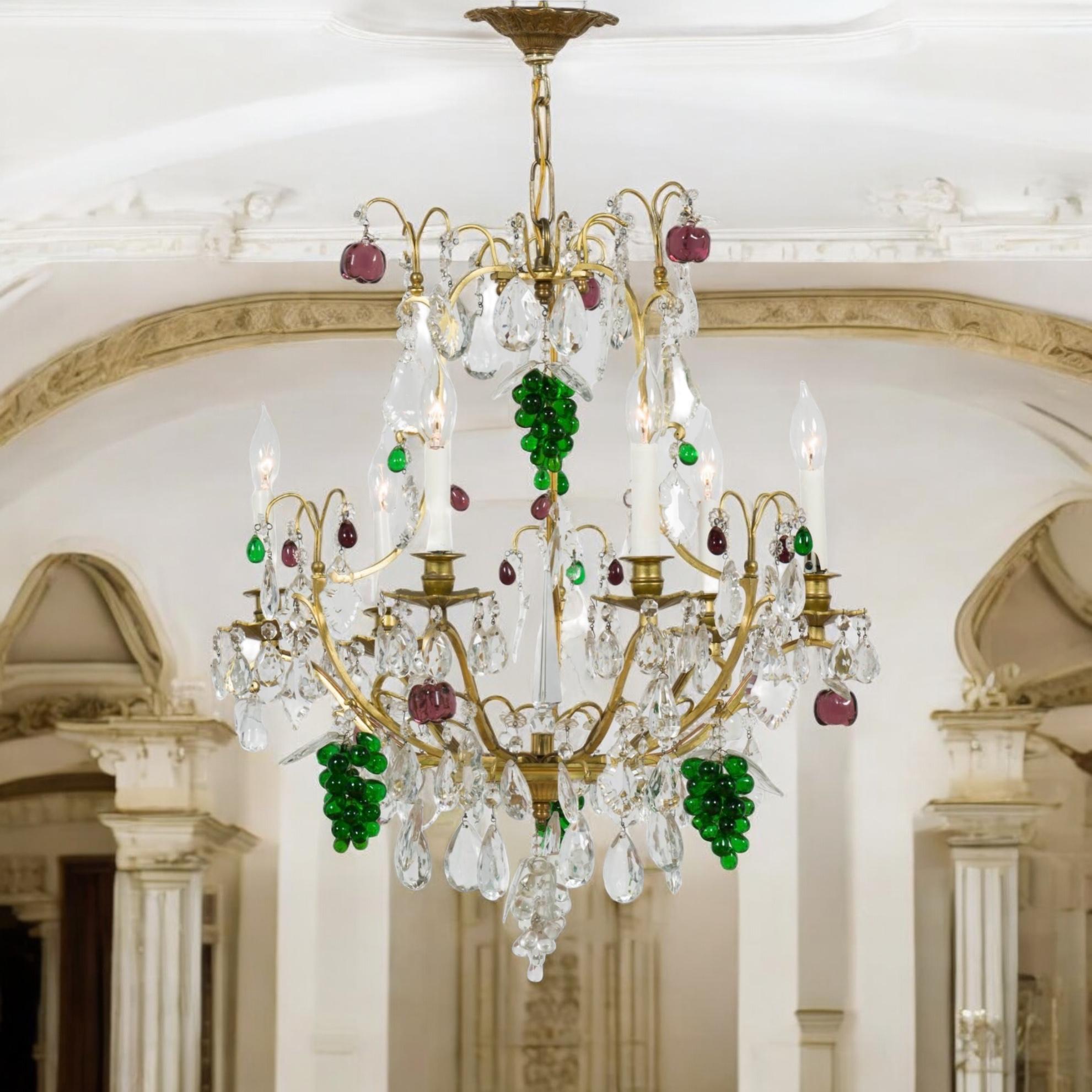 This is such a pretty chandelier! It is French and over flowing with crystals and glass fruit. The fruit is purple, green, and clear. Please note the fabulous prism in the center of the 6 arms. It is marked and in working order. Perfect for that