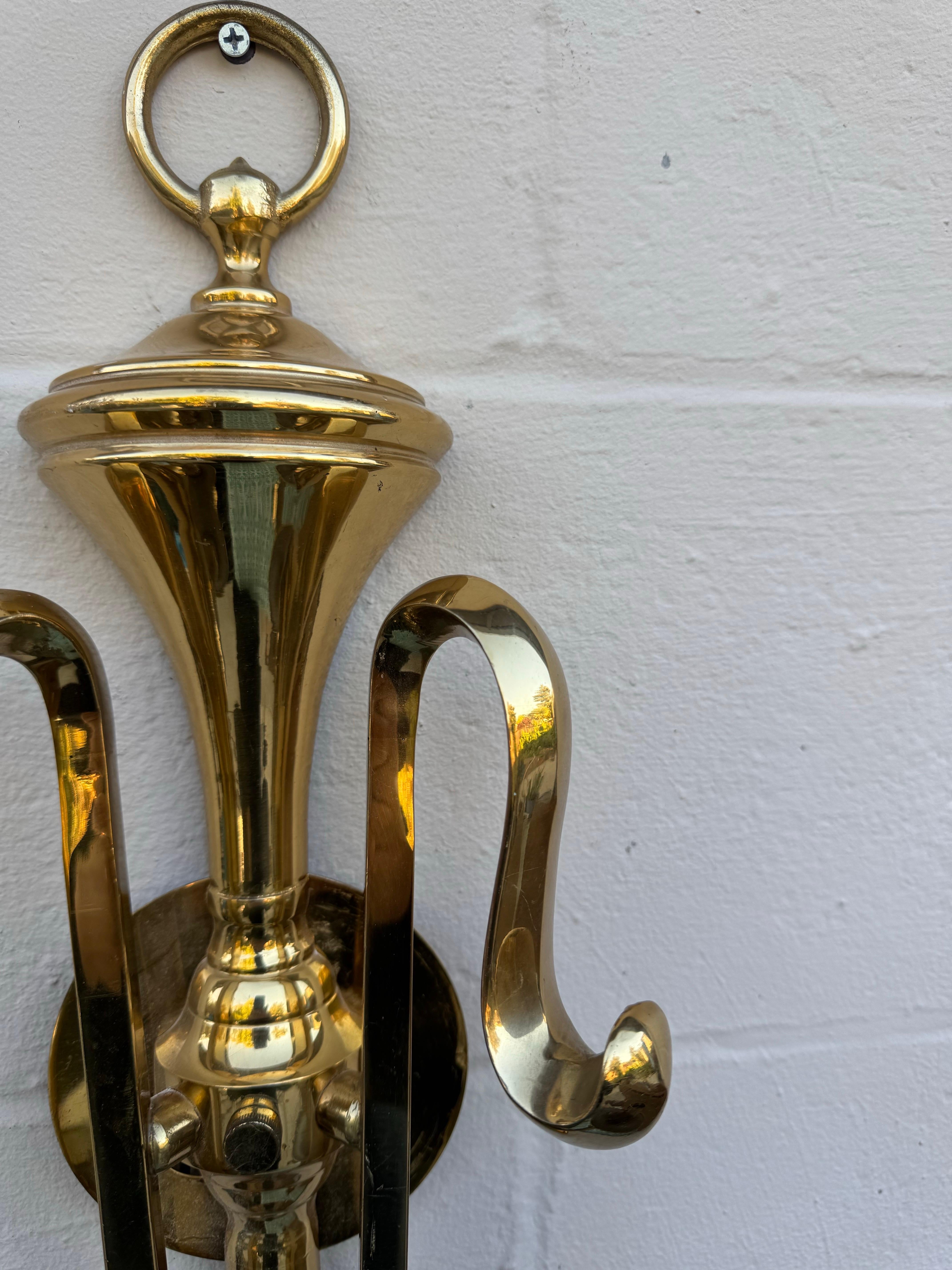 Elegant Mid-Century Brass Double Arm Wall Sconce, France, 1970s

Dimensions: 14.5” W x 21” H x 7” D

This striking Mid-Century brass wall sconce features a graceful urn-shaped backplate and beautifully scrolled arms, making it a refined addition to