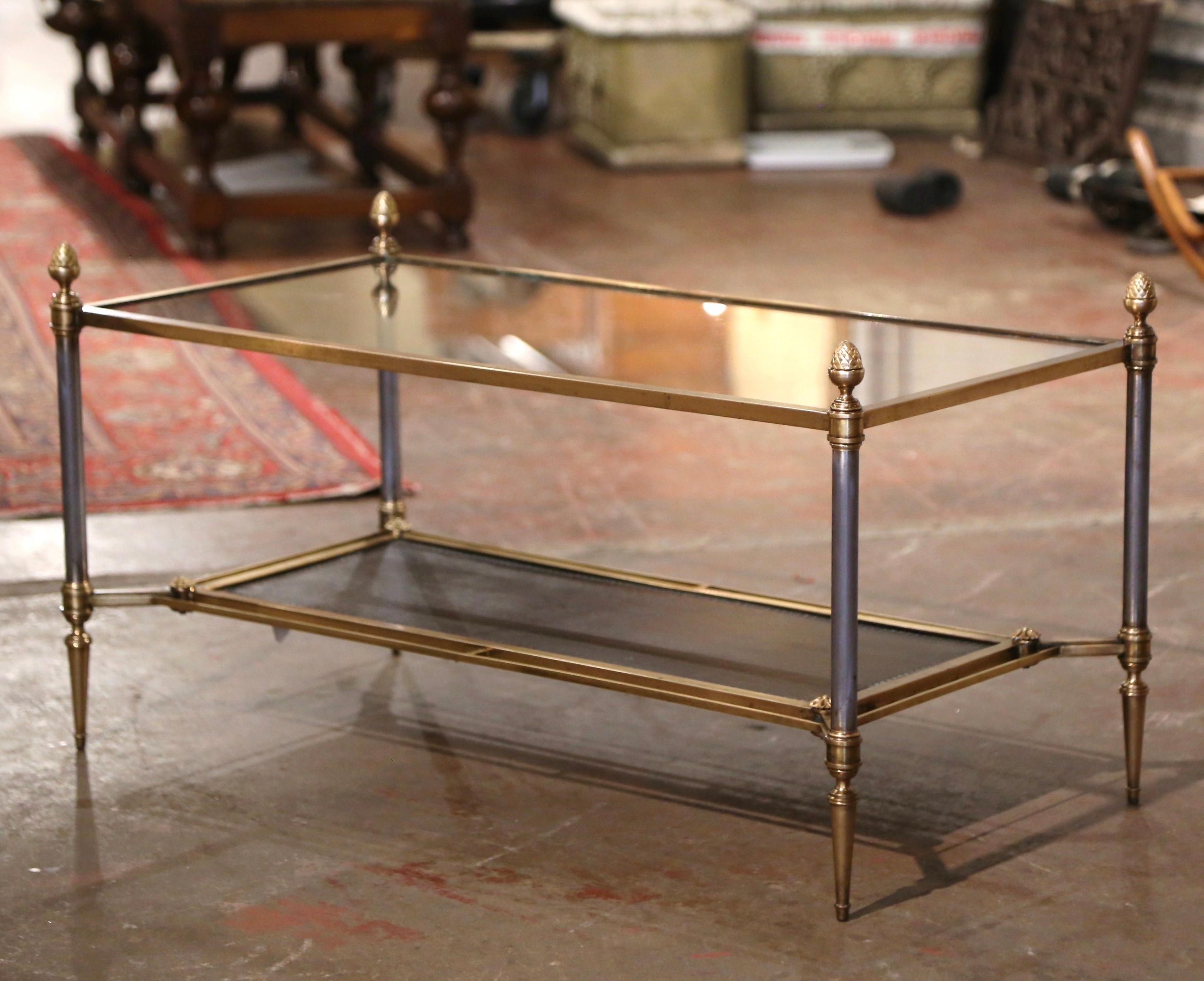 Decorate a living room or den with this elegant two-tier antique coffee table. Created in Paris, France, circa 1950 by Maison Jansen, the clean line frame is made of brushed steel and brass; it features round legs ending with tapered feet, and is