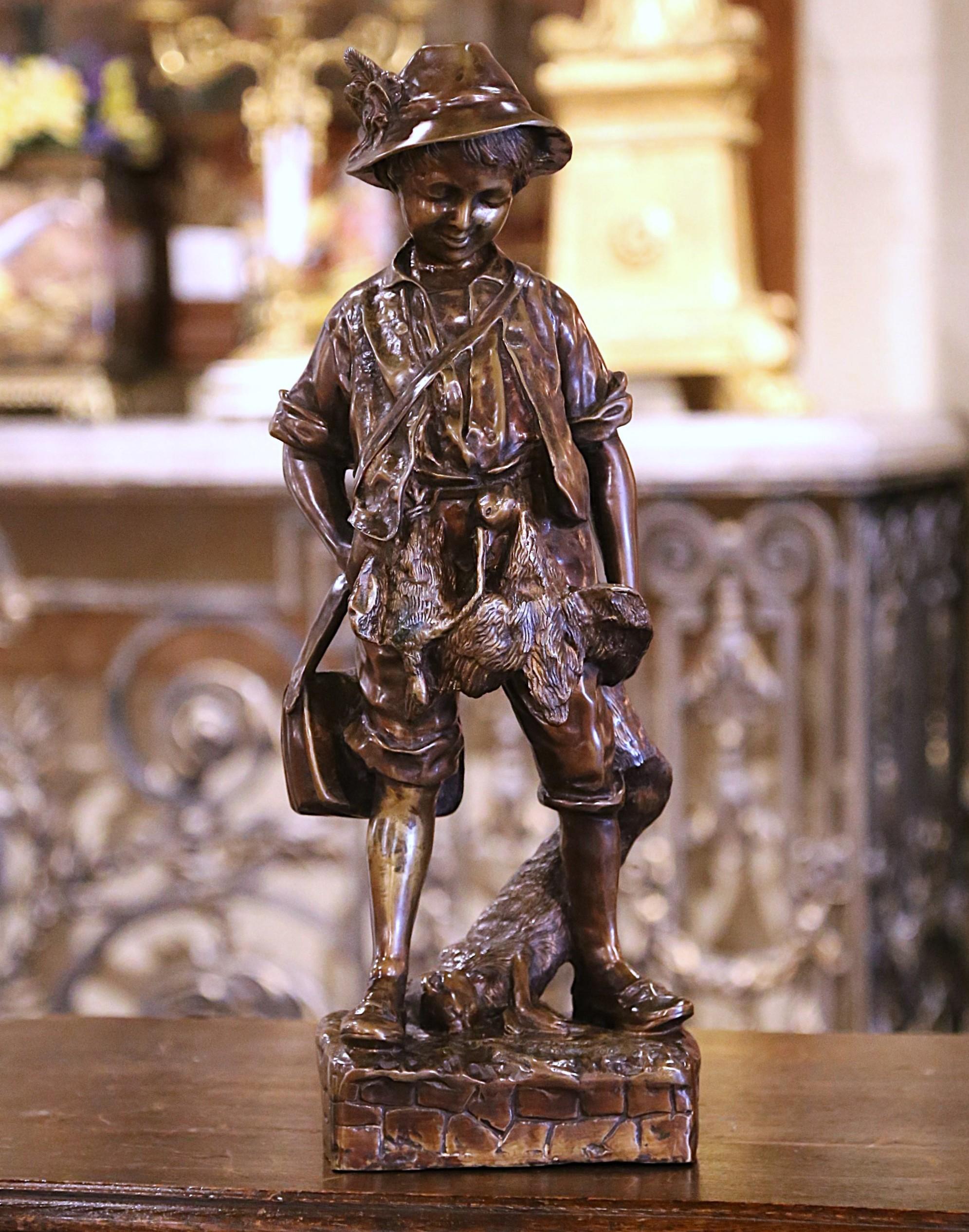 Decora un ufficio o uno studio con questa bellissima figura in bronzo antico. Realizzata in Francia, intorno al 1950, la scultura raffigura un giovane cacciatore bucolico che trascina un coniglio in una mano, con un piccolo zaino sulla spalla e due