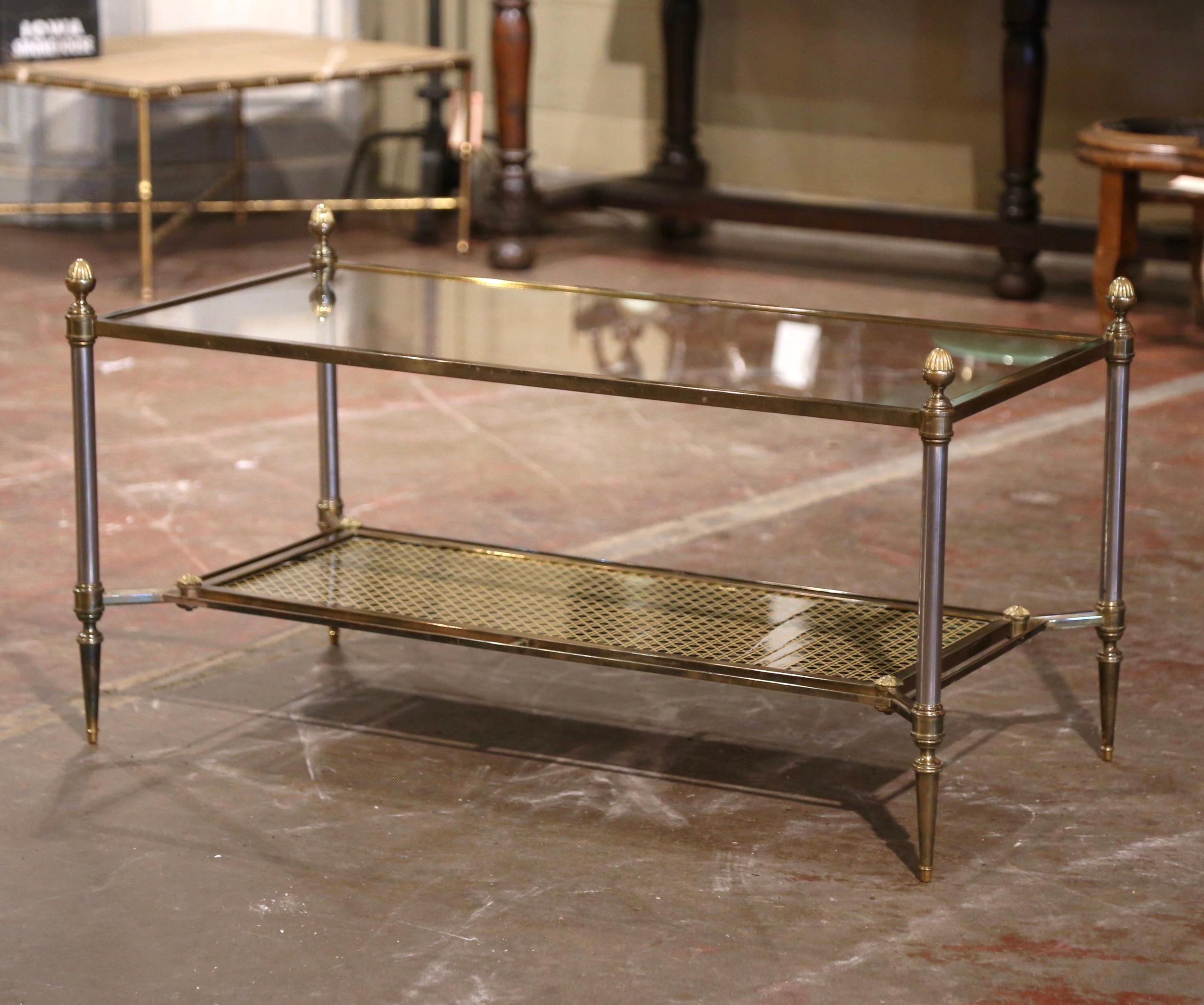 Decorate a living room or den with this elegant two-tier antique coffee table. Created in Paris, France, circa 1950 by Maison Jansen, the clean line frame is made of brushed steel and brass; it features round legs ending with tapered feet, and is