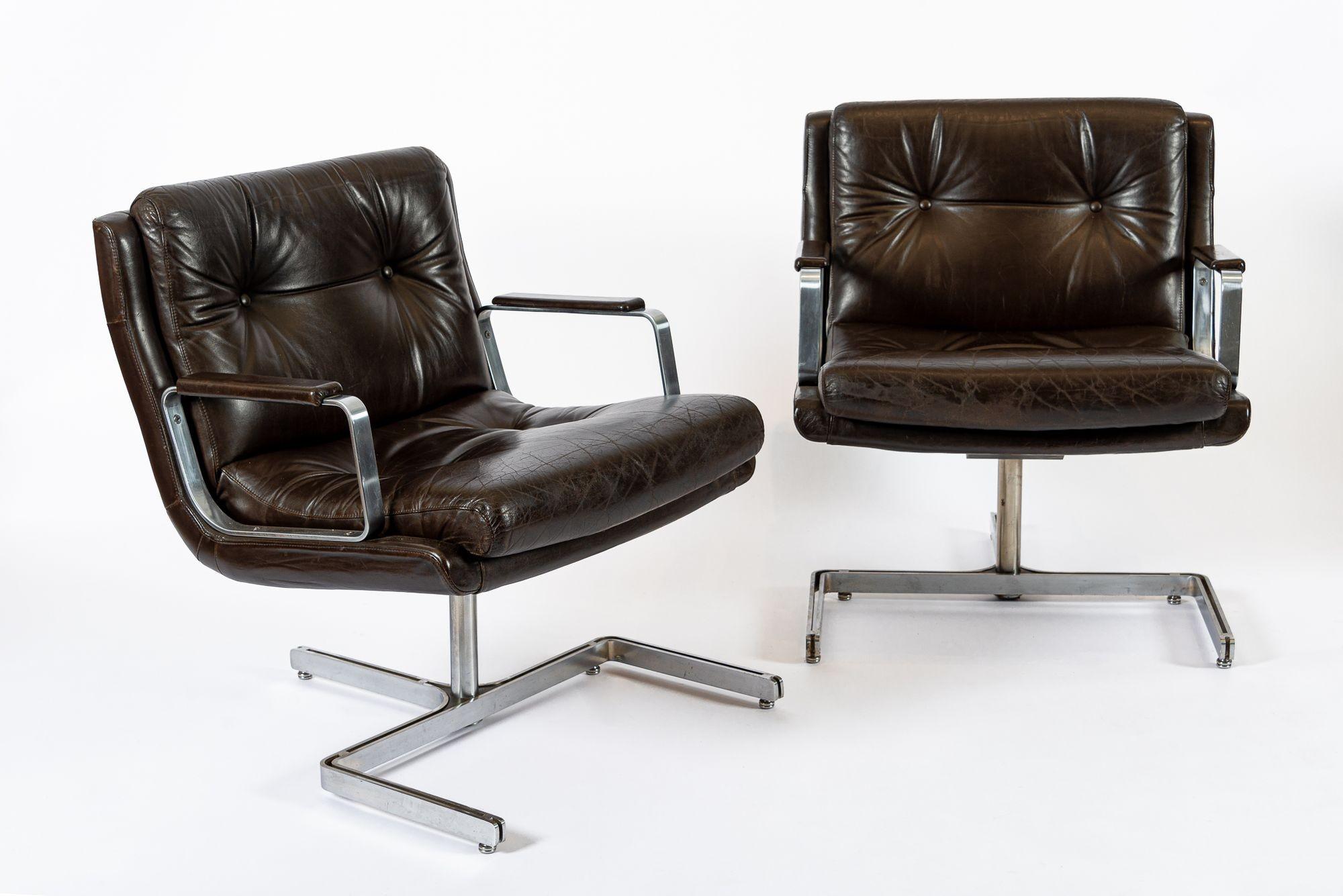 This stunning pair of vintage mid century modern lounge chairs were designed by Raphael Raffel and made in France circa 1970. These matching arm chairs are exceptionally well-made with original upholstery in a gorgeous rich, dark brown leather with