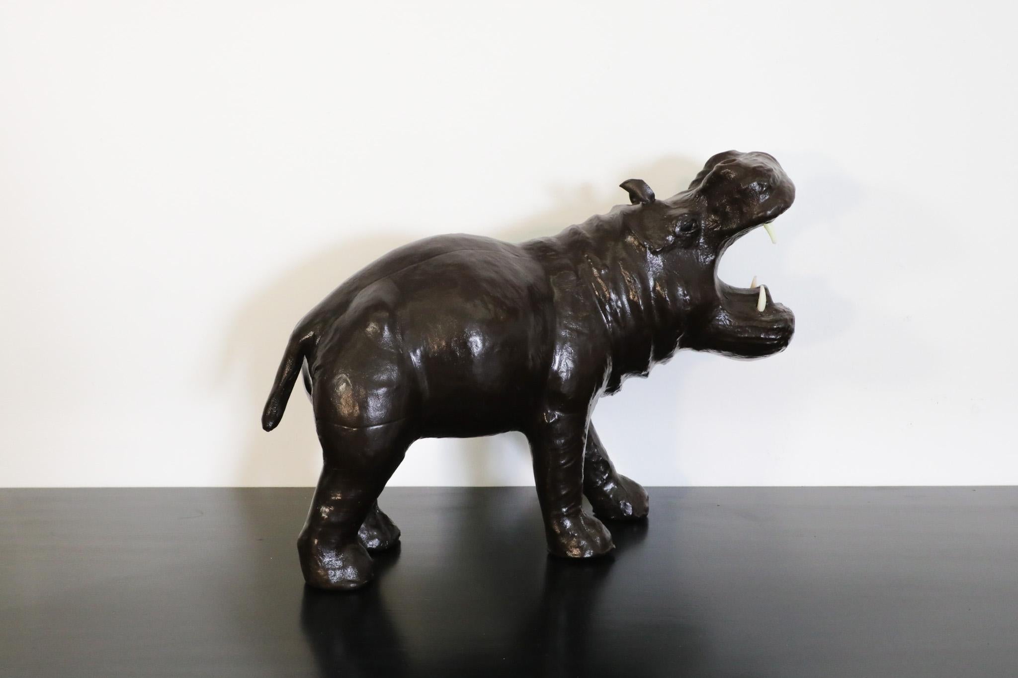 Beautiful Mid-Century hippopotamus sculpture crafted in France. The detailed leather figure is in excellent condition and adorns a rich patinated finish. the hippo's mouth is open and bears four pointy teeth. Perfect sculpture for a shelf in a study