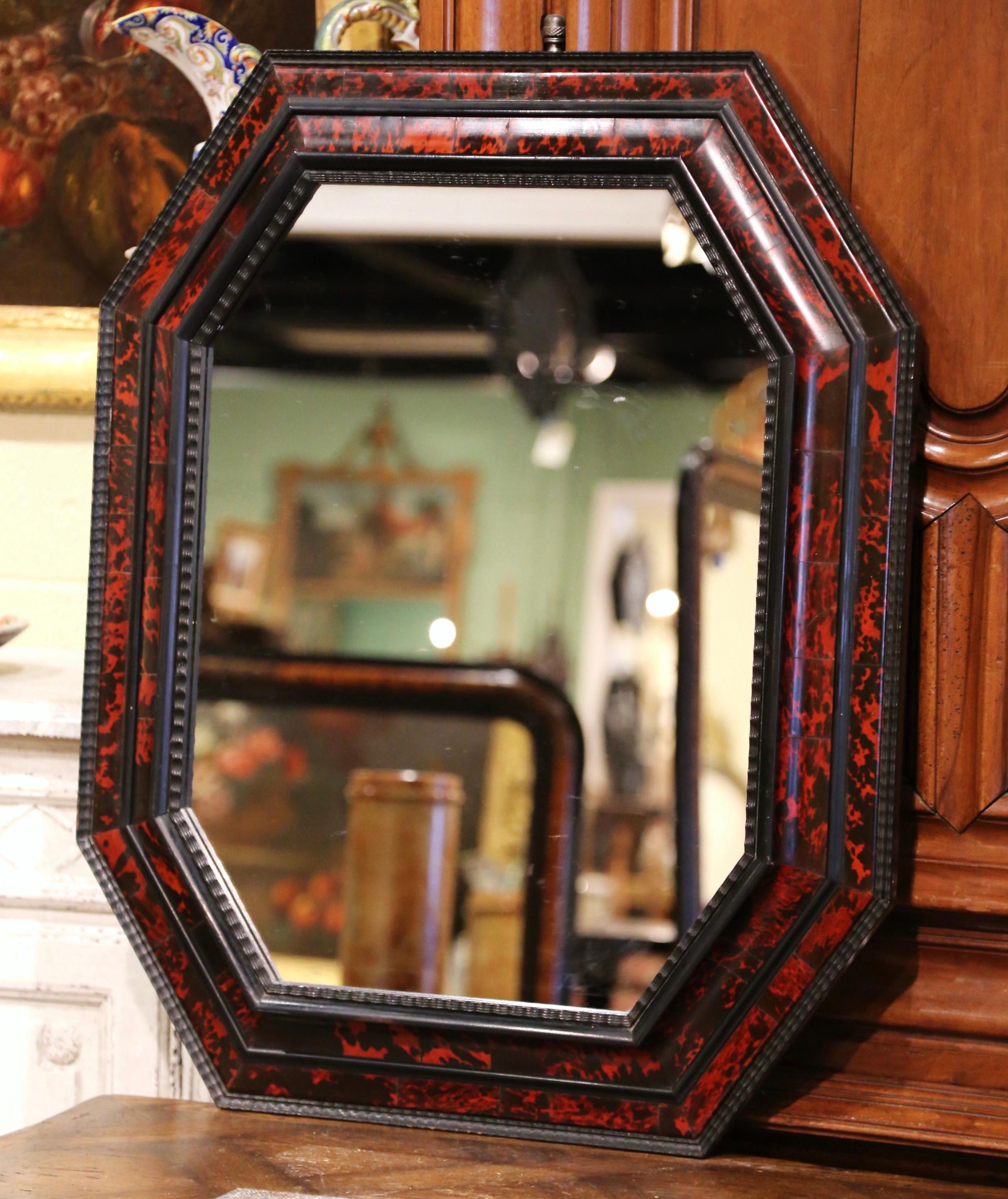 This elegant antique mirror in the style of Maison Jansen, was created in Paris, France circa 1950. Octagonal and overlay in shape, the Renaissance style mirror is decorated with faux tortoiseshell motifs around the frame. The wall piece is in