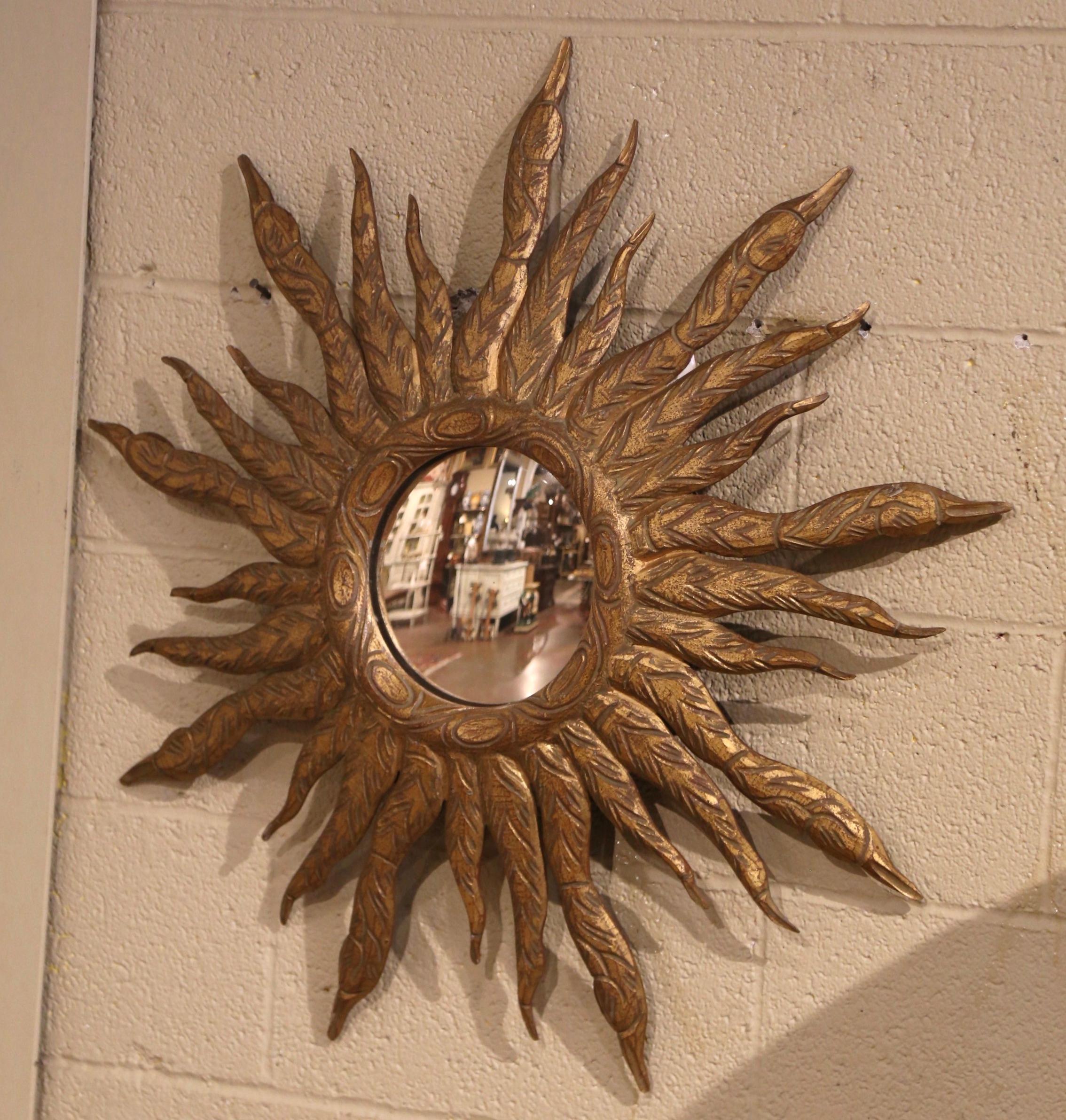 Añade un hermoso brillo a tu hogar con este gran espejo solar de gran vistosidad. Tallado a mano en Francia hacia 1970, el marco en forma de rayo de sol irradia rayos de sol atrevidos y estilizados, plasmados en madera dorada, lo que confiere a la