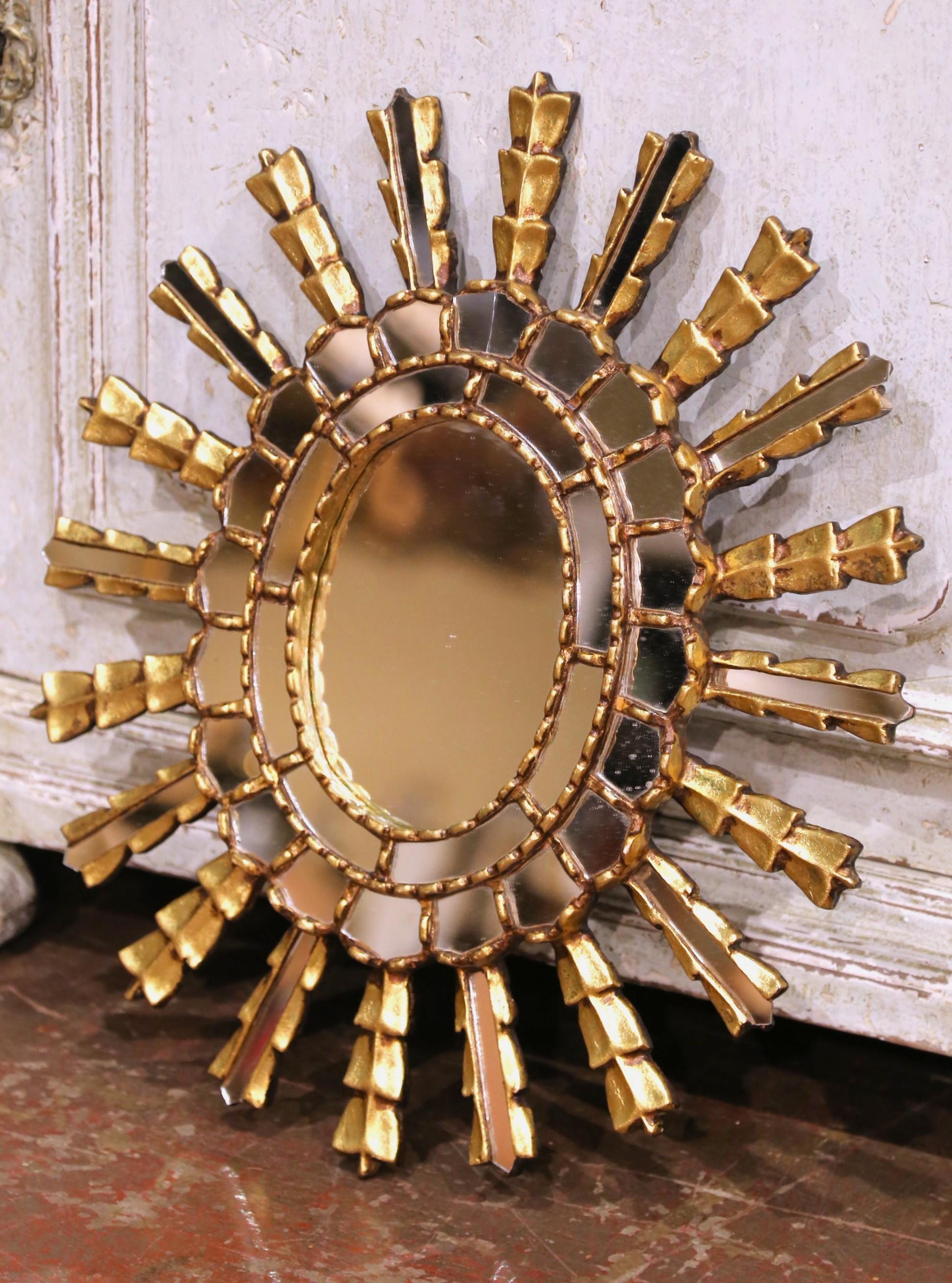 Ce remarquable miroir en forme de soleil a été fabriqué en France vers 1950 et illustre l'audace et le flair décoratif du design du milieu du siècle. Le cadre est composé de poutres rayonnantes disposées en gradins alternés, chacune revêtue d'une