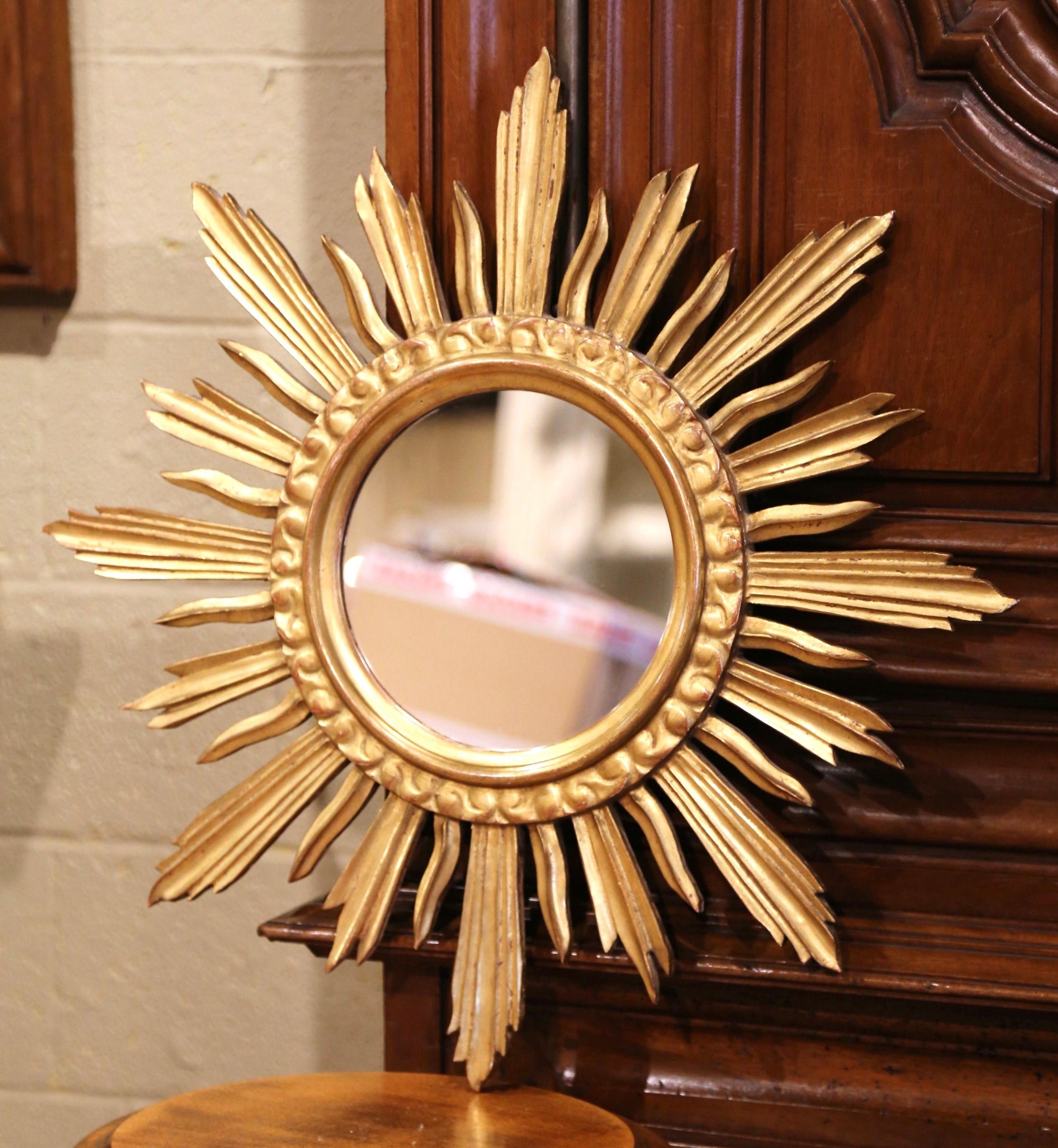 Add a beautiful shine to your home with this eye-catching and elegant sunburst mirror from Versailles, France. Created circa 1970, the giltwood wall decor has a classic sunbeam shape, a round convex glass in the center, and a rich rubbed gold leaf