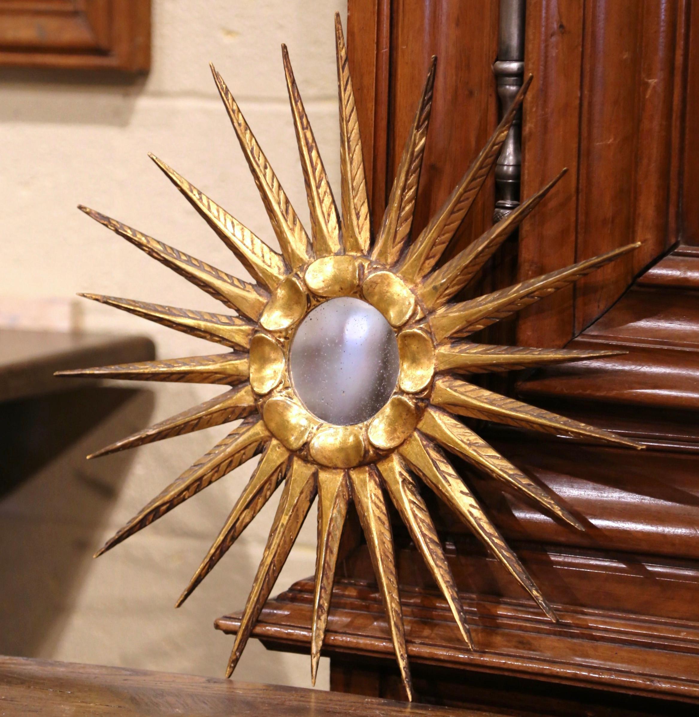 Add a beautiful shine to your home with this eye-catching and elegant gilt sunburst mirror. Crafted in Versailles, France circa 1960, the giltwood wall decor has a classic sunbeam shape with long and tapered rays, a round convex glass in the center.