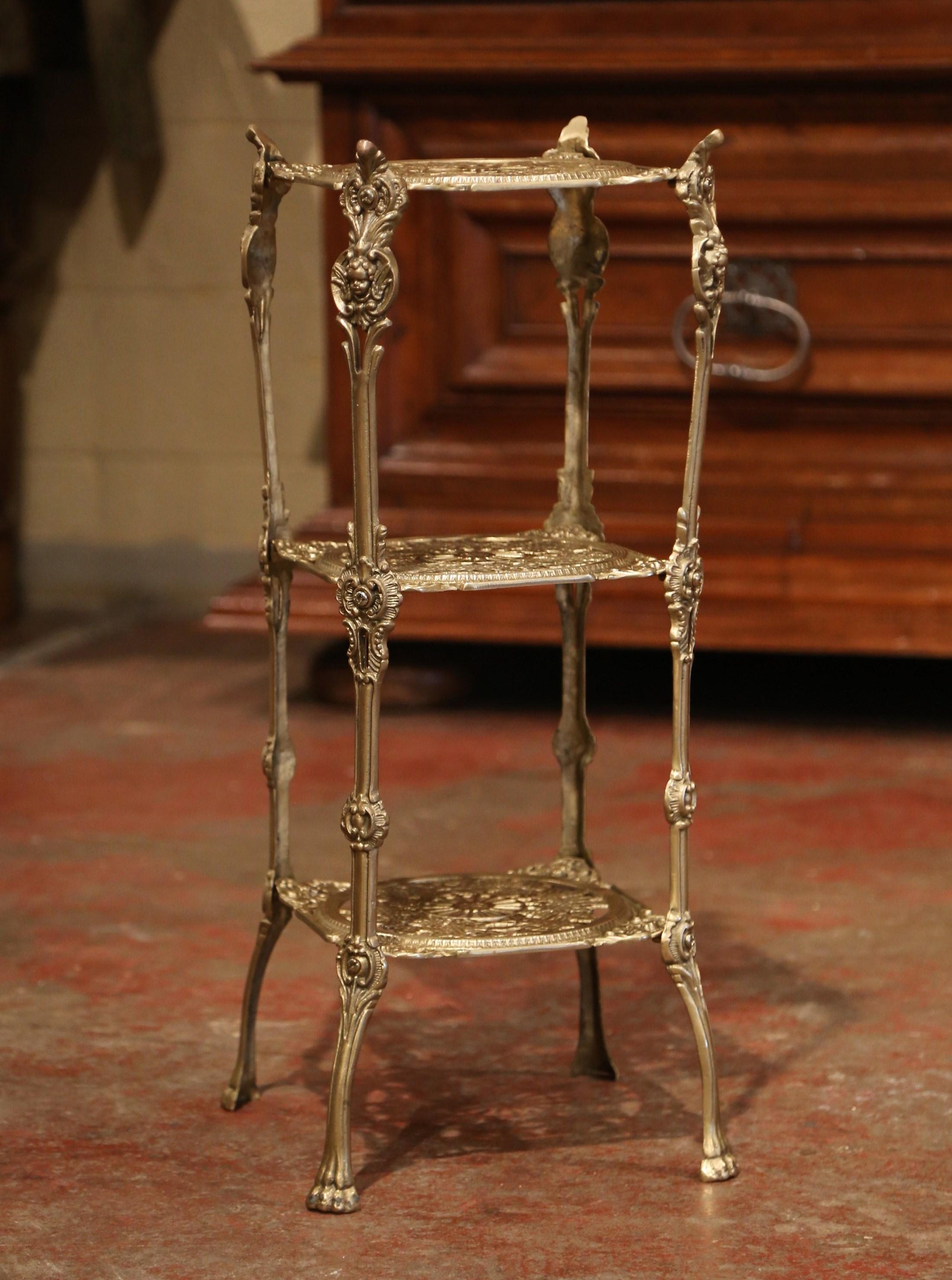 Decorate a powder room with this antique small table stand. Crafted in France circa 1950, the bronze table stands on four curved legs with paw feet at the base, and features three shelves decorated with pierced grape and vine motifs. The square