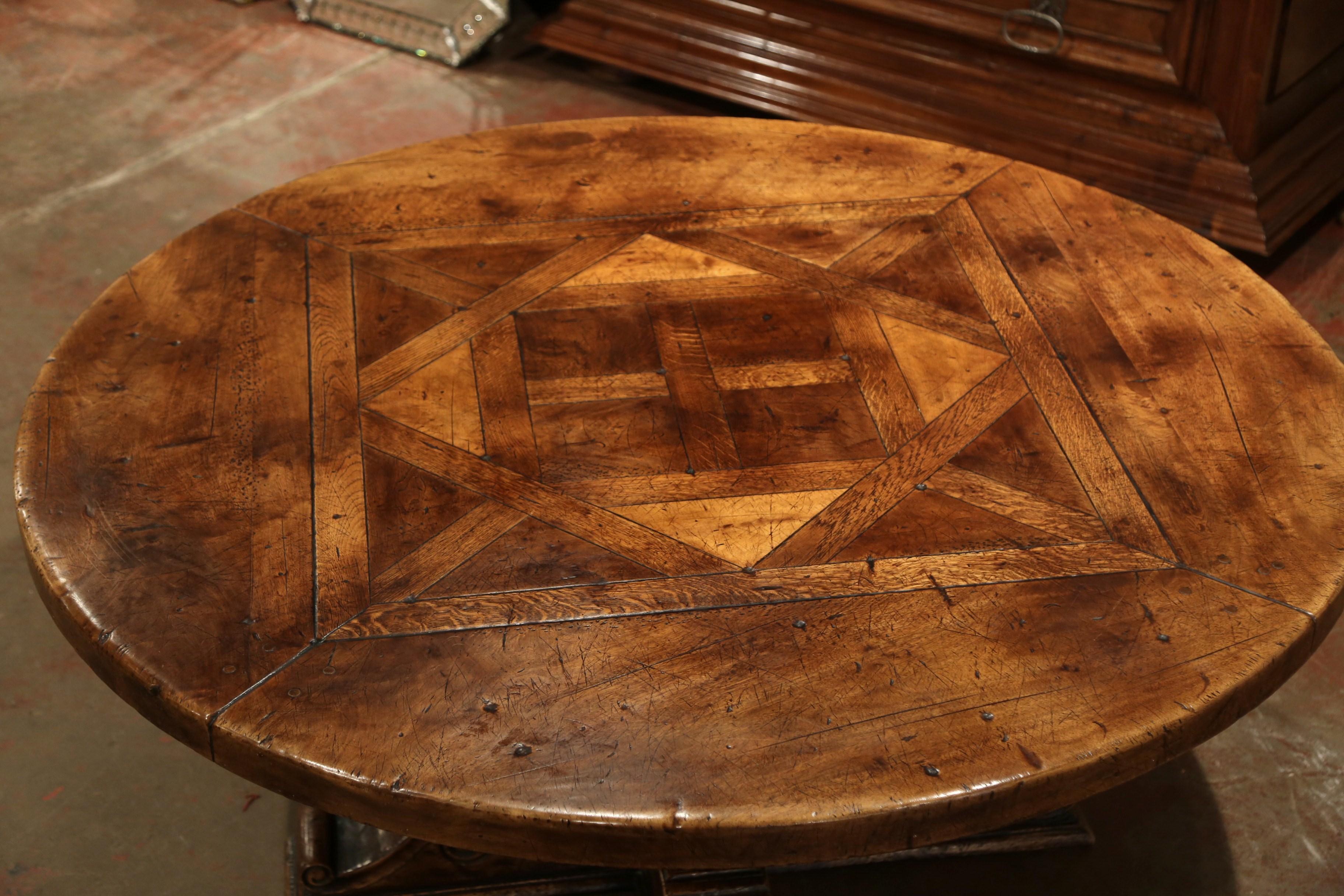 Crafted in the Pyrenees mountains of France half a century ago, the thick round surface features a parquet and geometric decor made with antique wood species, including walnut, chestnut, burl and oak. The sturdy pedestal base features four hand