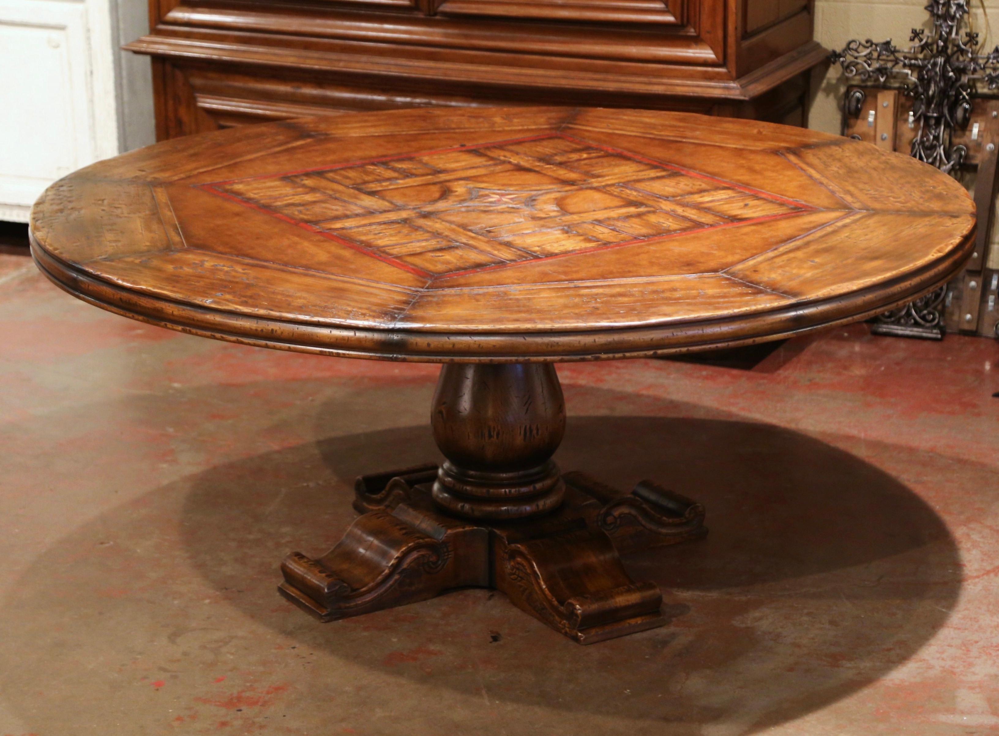 Crafted in the Pyrenees mountains of France half a century ago with 18th and 19th century old timber, the six foot round table stands on an elegant hand carved central column base, supported with four flat carved feet for ultimate stability. The