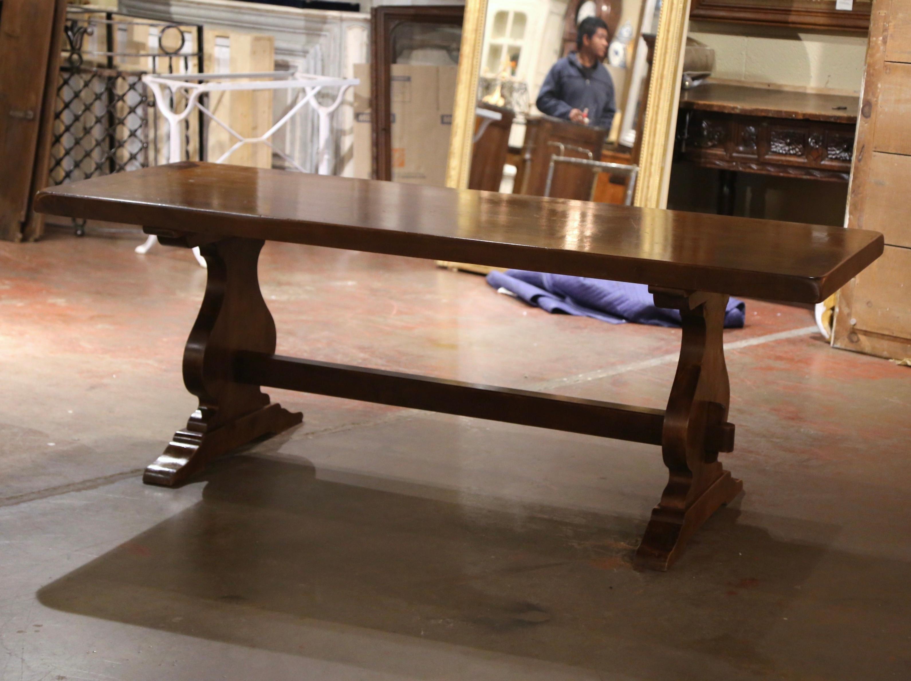 Cette élégante table de réfectoire ancienne a été fabriquée en Normandie, France, vers 1960. Construite en noyer massif, cette table imposante s'étend sur plus de 2,5 mètres de long. La base de style monastère comporte de grands pieds balustres
