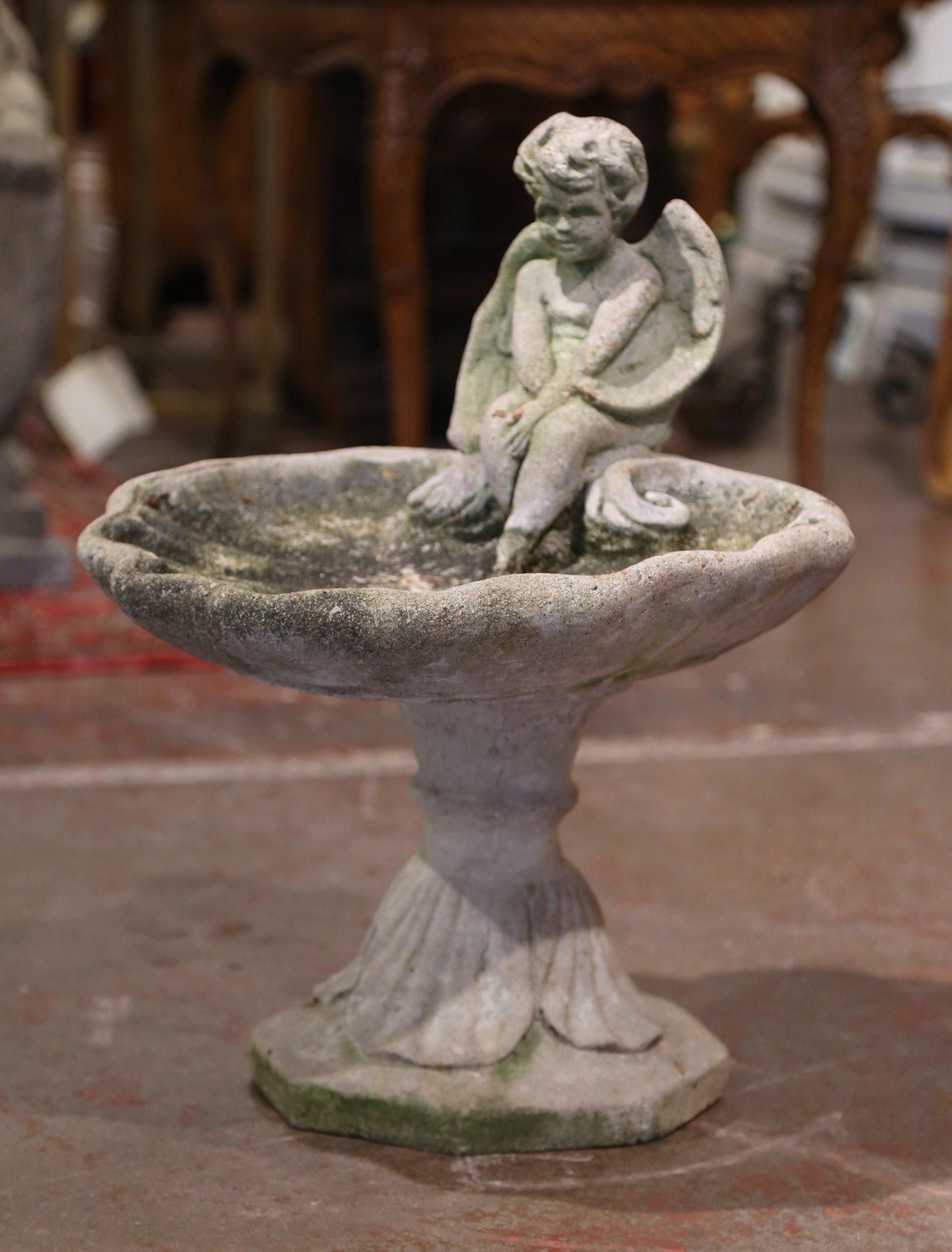 Decorate a garden with this elegant antique outdoor two-piece sculpture; hand carved in France circa 1950, the sculpture features a carved cherub over the shell shape basin. The piece is in excellent condition with a rich patinated weathered