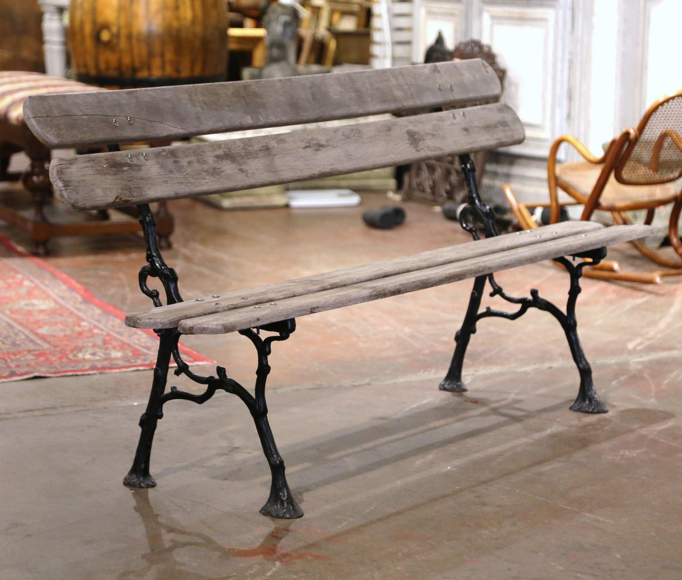 Create extra seating on your patio or in your backyard with this large iron and wooden bench. Crafted in Normandy, France circa 1960, the antique park bench stands on carved iron tree branch form legs ending with rounded feet. The long sturdy bench