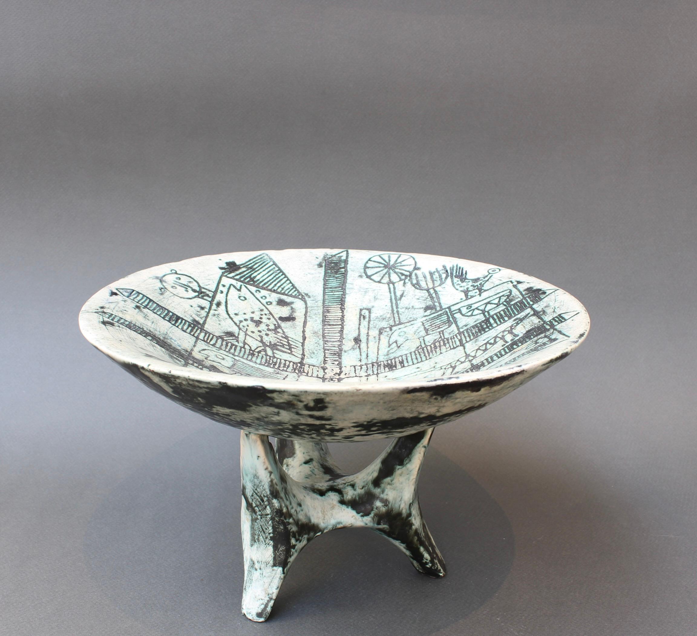 Mid-Century French ceramic, shallow bowl on tripod support by Jacques Blin (circa 1950s). The piece may more specifically called: 'The Farm and its Animals' due to its unique decor by Blin's longtime collaborator, Jean Rustin. A very rare ceramic