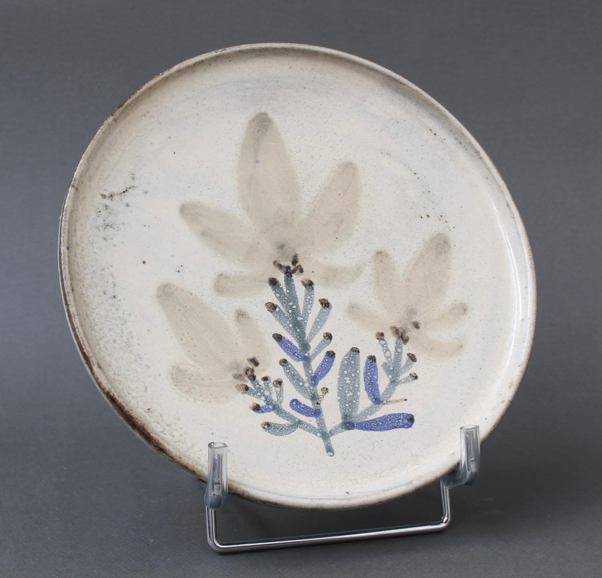 Mid-century French ceramic decorative plate by Le Mûrier (circa 1960s). A seductive piece with their signature style, chalk-white colour base with stylised plant motif. In good overall condition. Maker's mark on the underside, Le Mûrier's trademark