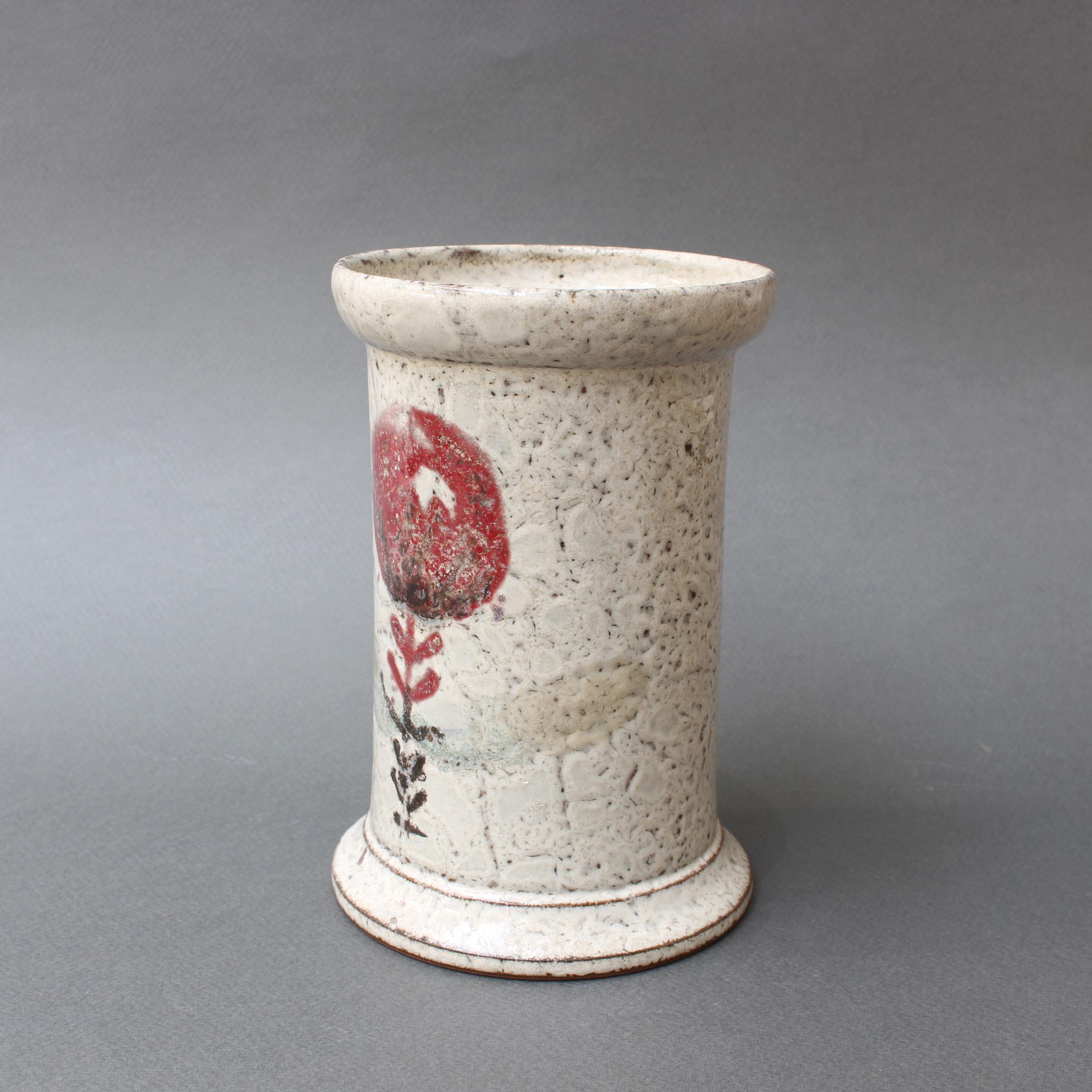 French ceramic jar with flower motif by Gustave Reynaud, (circa 1950s). Delightfully rustic earthenware piece with decor of a red, round flower and stylized rosemary herb branch on the opposite side of the vessel. In fair vintage condition