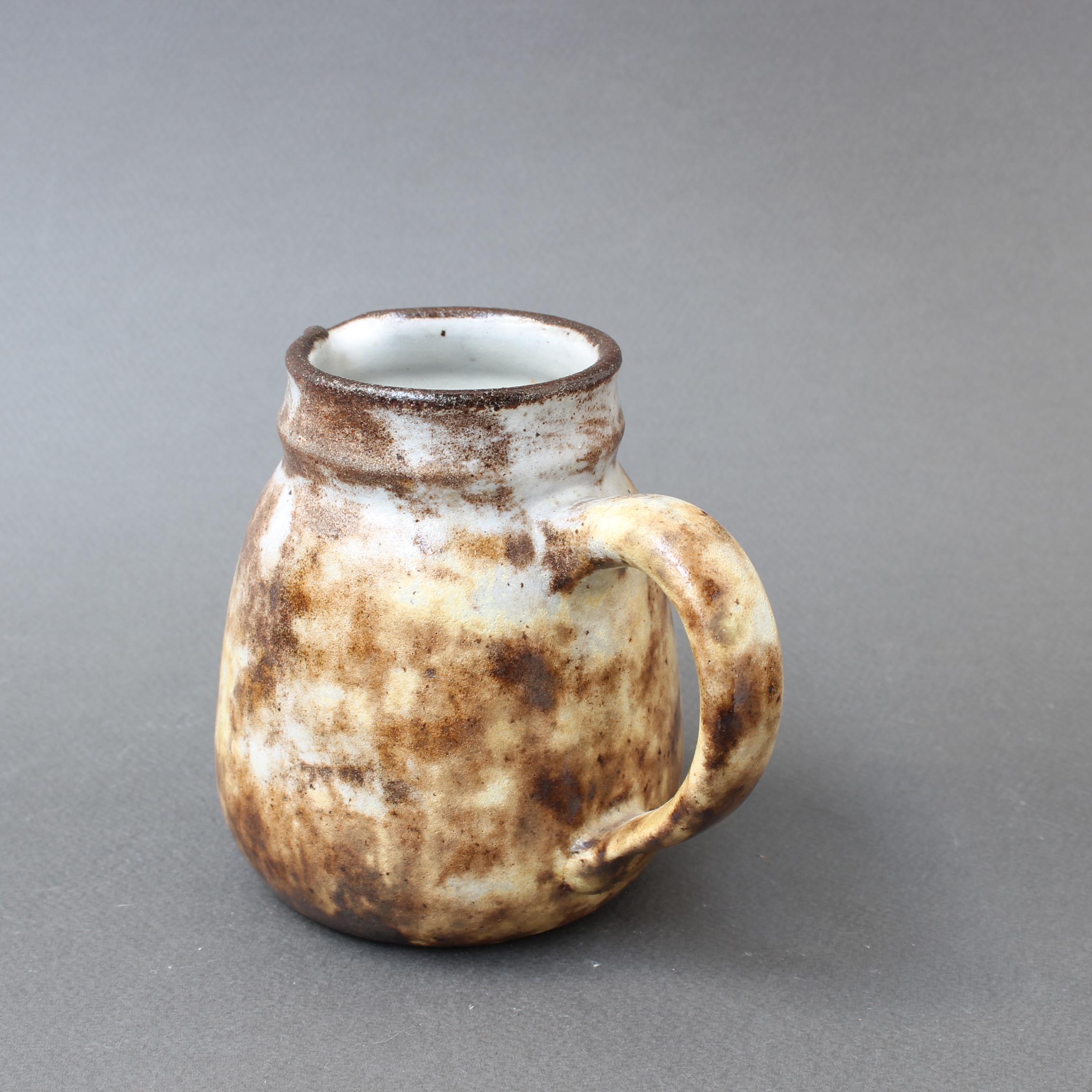 Midcentury, small, ceramic jug by Alexandre Kostanda (circa 1960s). In his trademark natural clay and rustic style, Kostanda created beautifully original vessels, such as vases, pitchers and pots which were both utilitarian and stunning works of