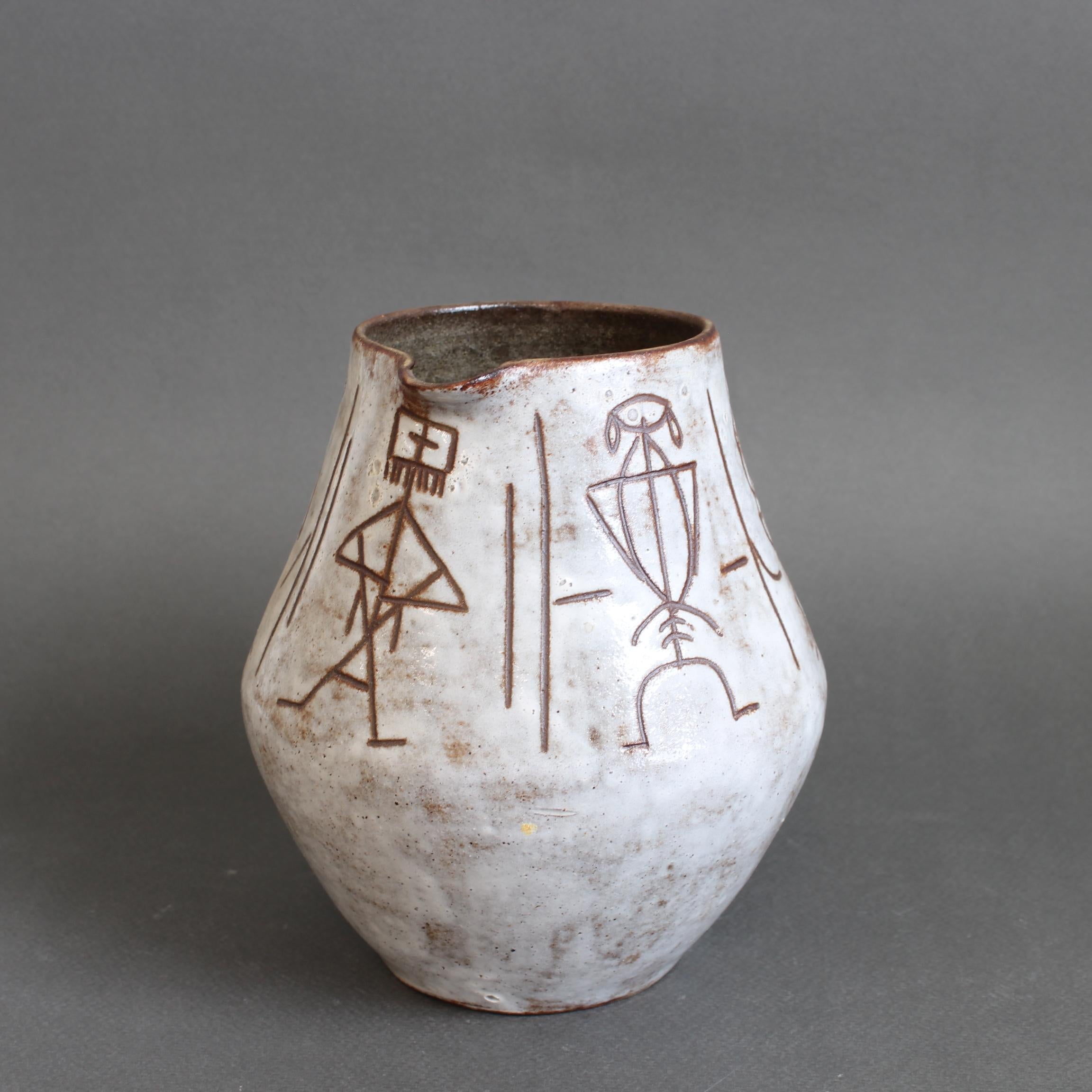 Pichet / vase en céramique du milieu du siècle par Alexandre Kostanda (vers les années 1960). Ce magnifique récipient présente une base émaillée crémeuse associée à des lignes brunes et à des taches intentionnelles. La moitié supérieure de la forme