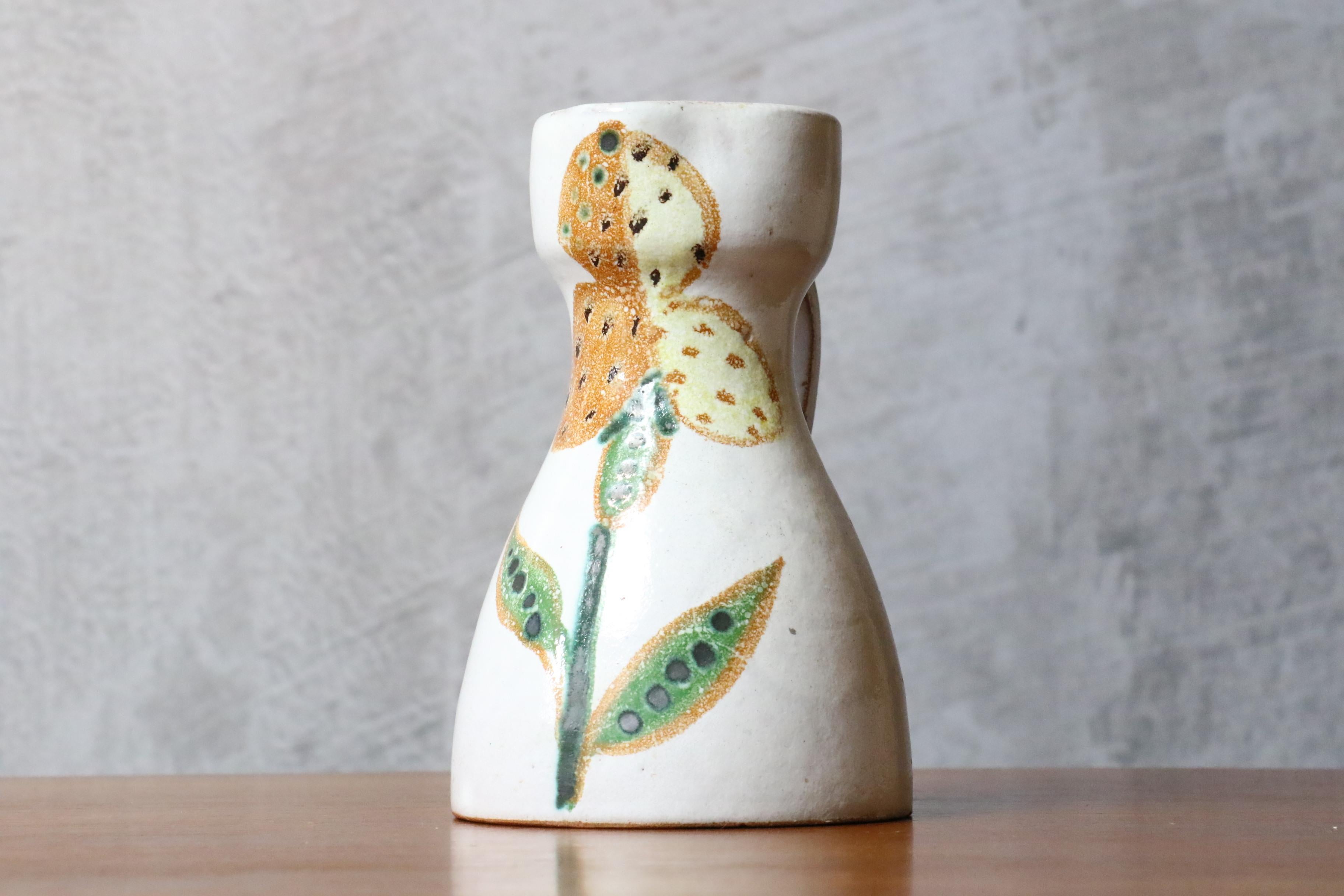 Mid-century French Ceramic Pitcher by Naumovitch - Grand Chêne Studio, Vallauris
Pitcher with a bright white background, it is glazed and decorated in an original way with and orange and yellow flower motif. 
The pitcher is in very good condition.
