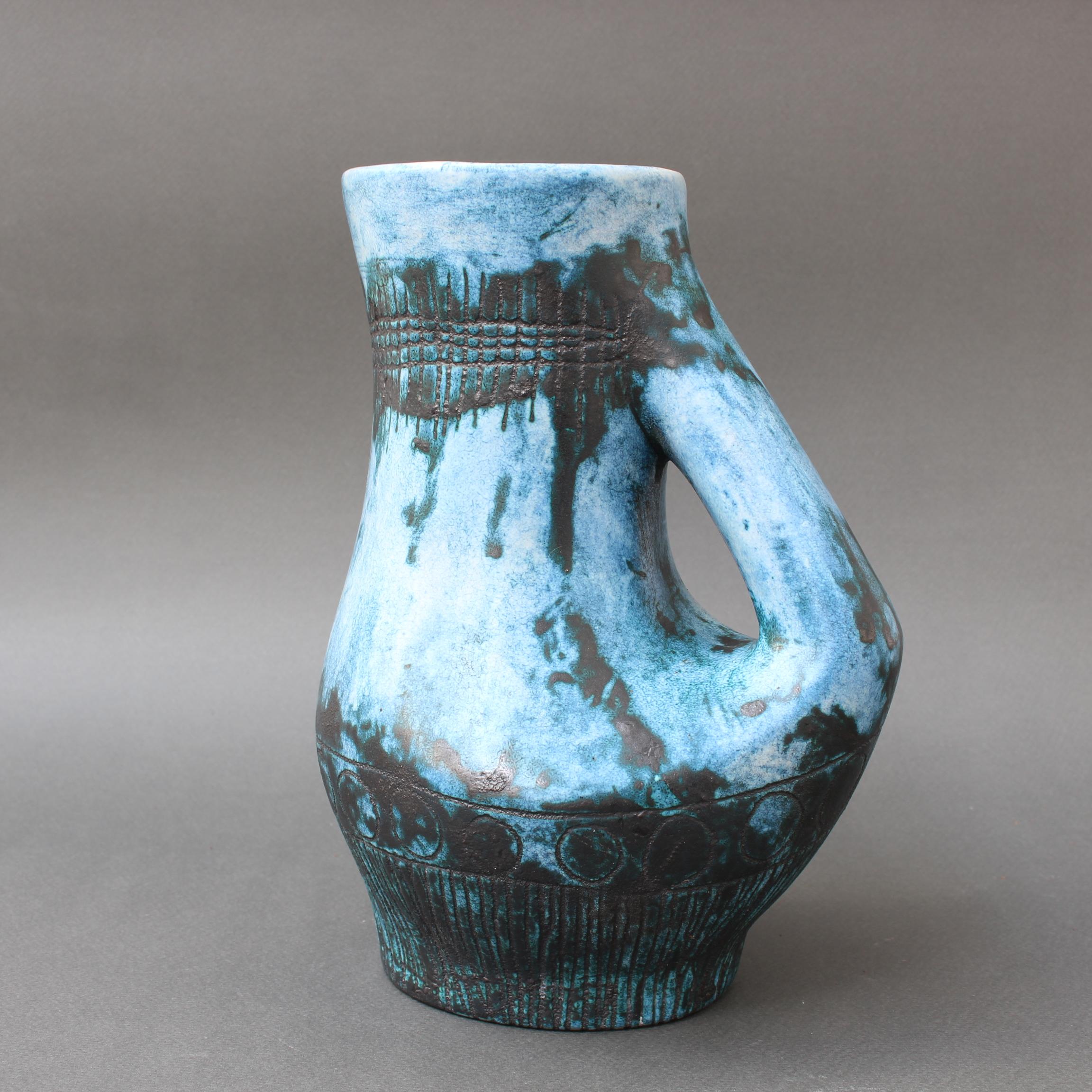 Vintage blue ceramic pitcher / vase by Jacques Blin (circa 1950s). This elegant ceramic pitcher has Blin's trademark cloudy blue glaze featuring a blackened, incised linear band with circles supported visually with vertical lines. Beneath the mouth