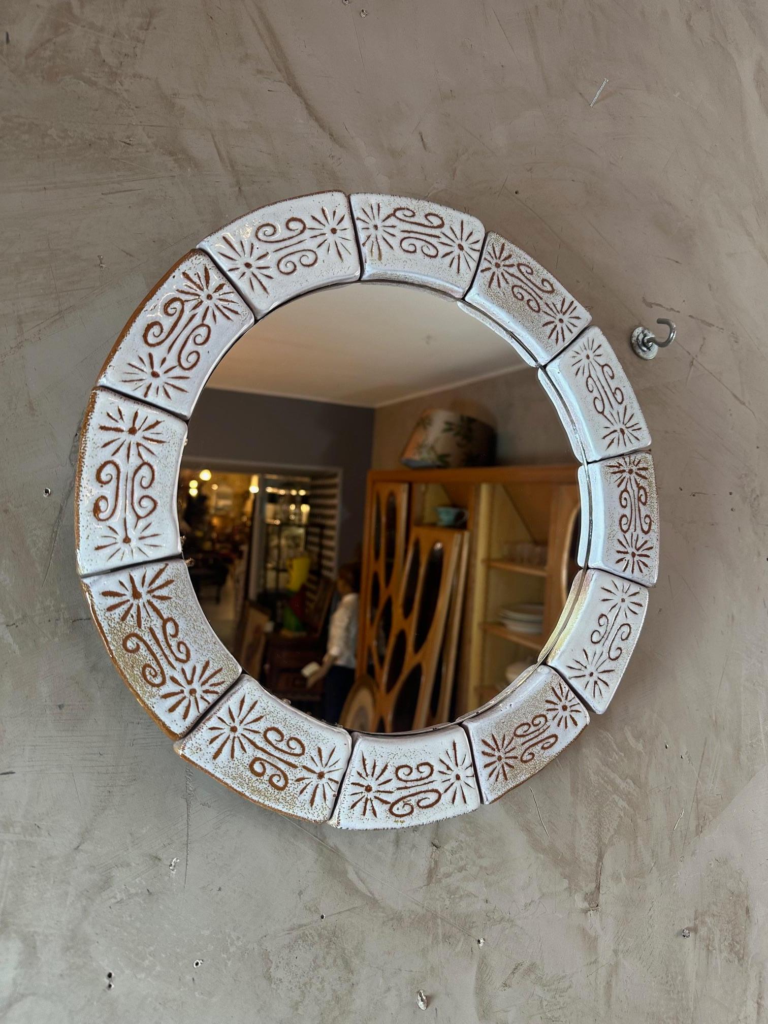 Beau miroir rond entouré de pièces en céramique beige et de décorations brunes datant des années 60, probablement fabriqué à Vallauris. Très bonne qualité.
