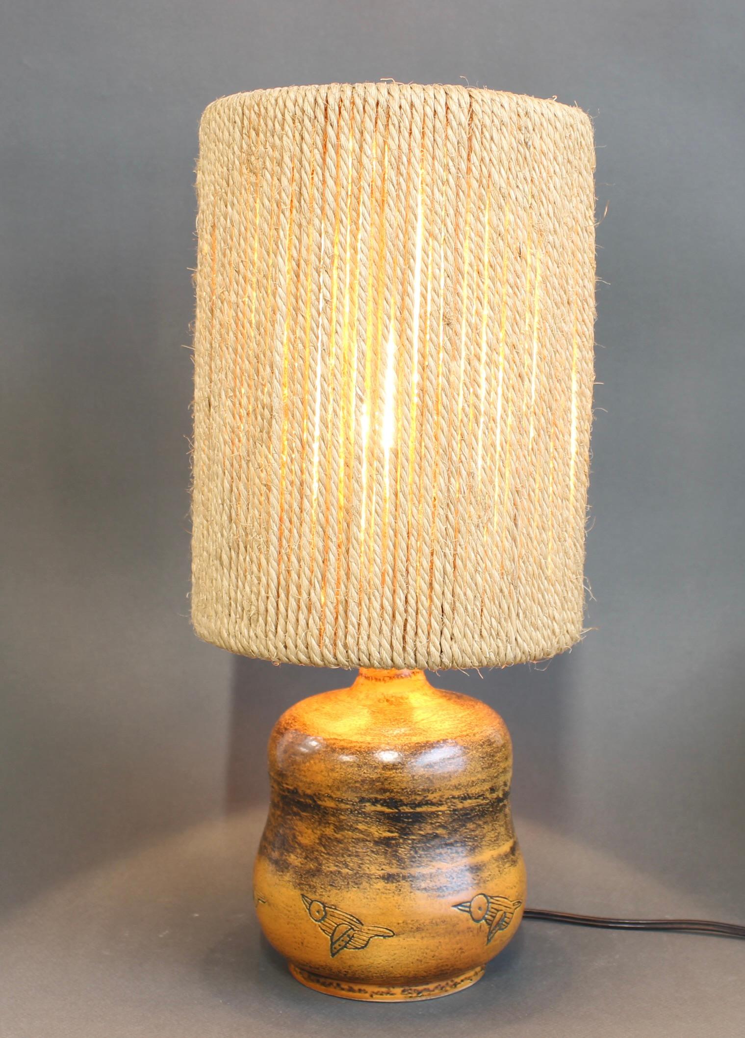 Lampe de table en céramique du milieu du siècle (circa 1950) par Jacques Blin. Cette magnifique lampe française de couleur rouille (C.C.C.), ornée d'oiseaux stylisés gravés au sgraffite, est en très bon état. La couleur est emblématique de l'Icone.