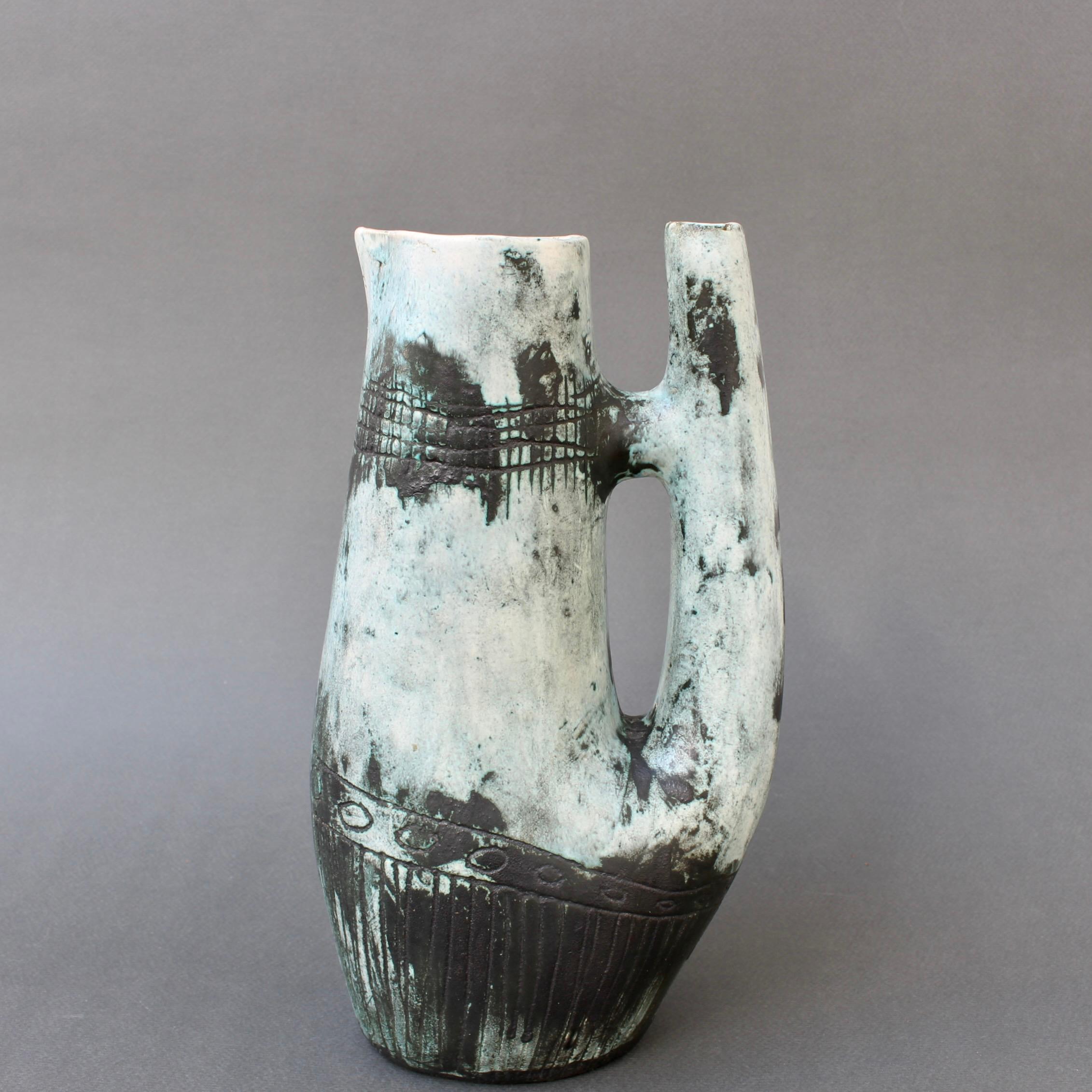 Pichet / carafe / vase décoratif en céramique française vintage (circa 1950s) par Jacques Blin. Le vase est d'une teinte subtile recouverte de la glaçure brumeuse caractéristique de Blin. Il est décoré d'une frise de cercles autour du corps,