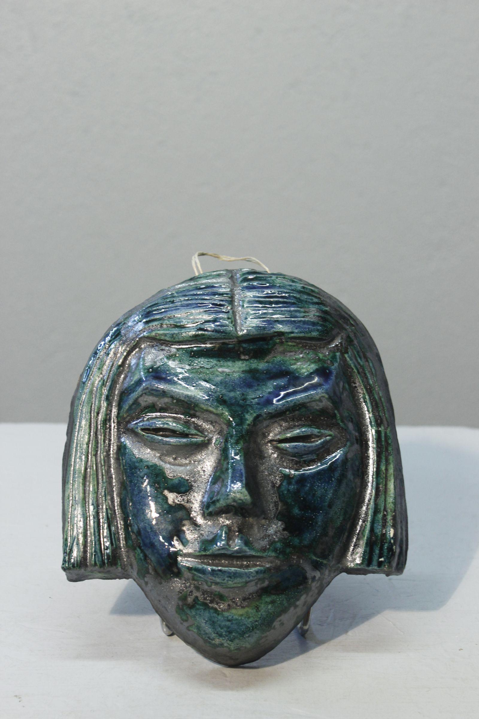 Glazed earthenware mask circa 1950, with a beautiful turquoise glaze that varies in texture. Signature on the back similar to those of Accolay. 

In very good condition. 