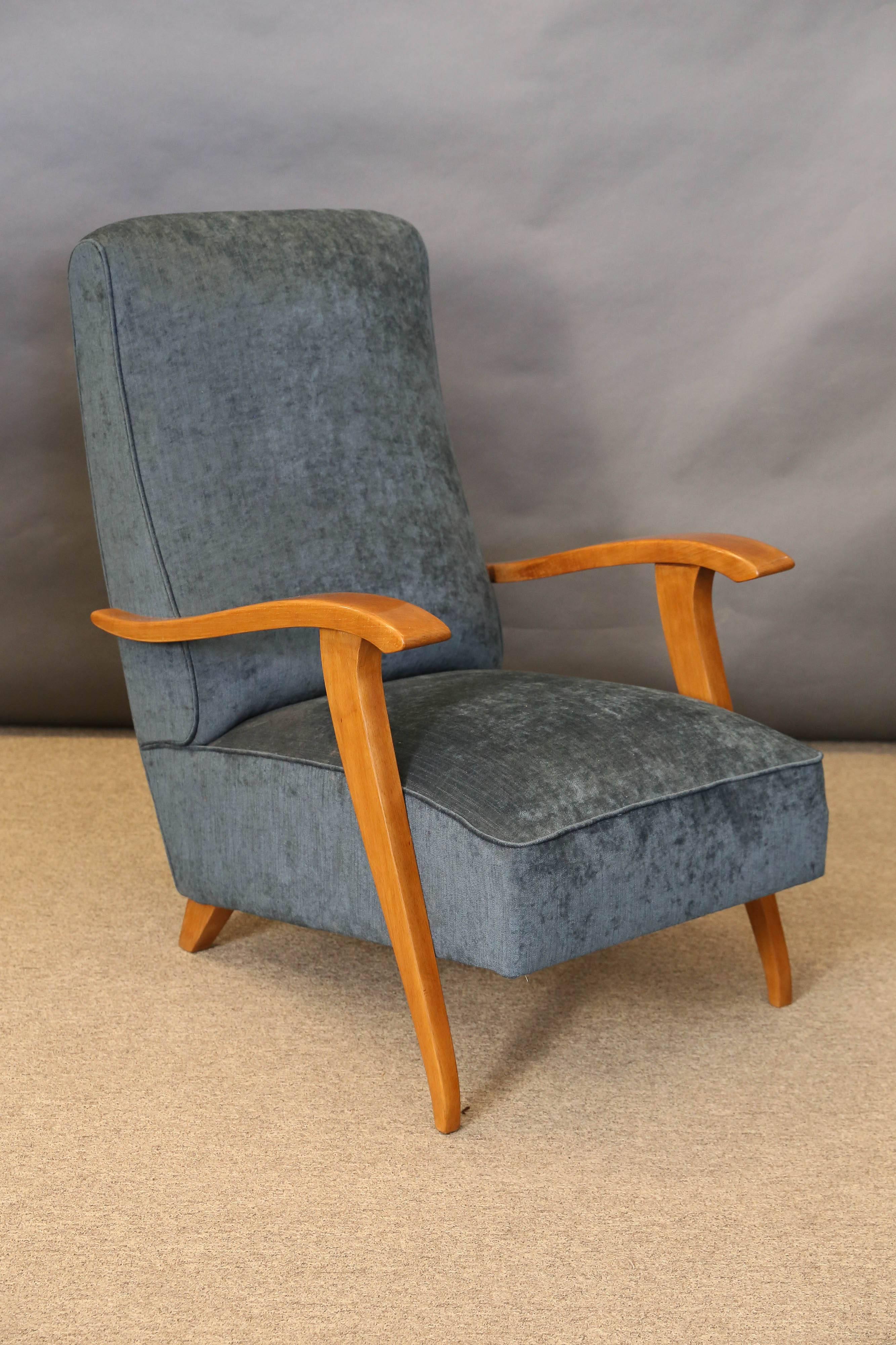 Each chair is newly re-upholstered in blue velvety fabric. Body of the chair is made out of beech wood. Back part of the chair is elevated be the small square legs. Front is elevated by skinny elongated legs that are connected to the bottom of each
