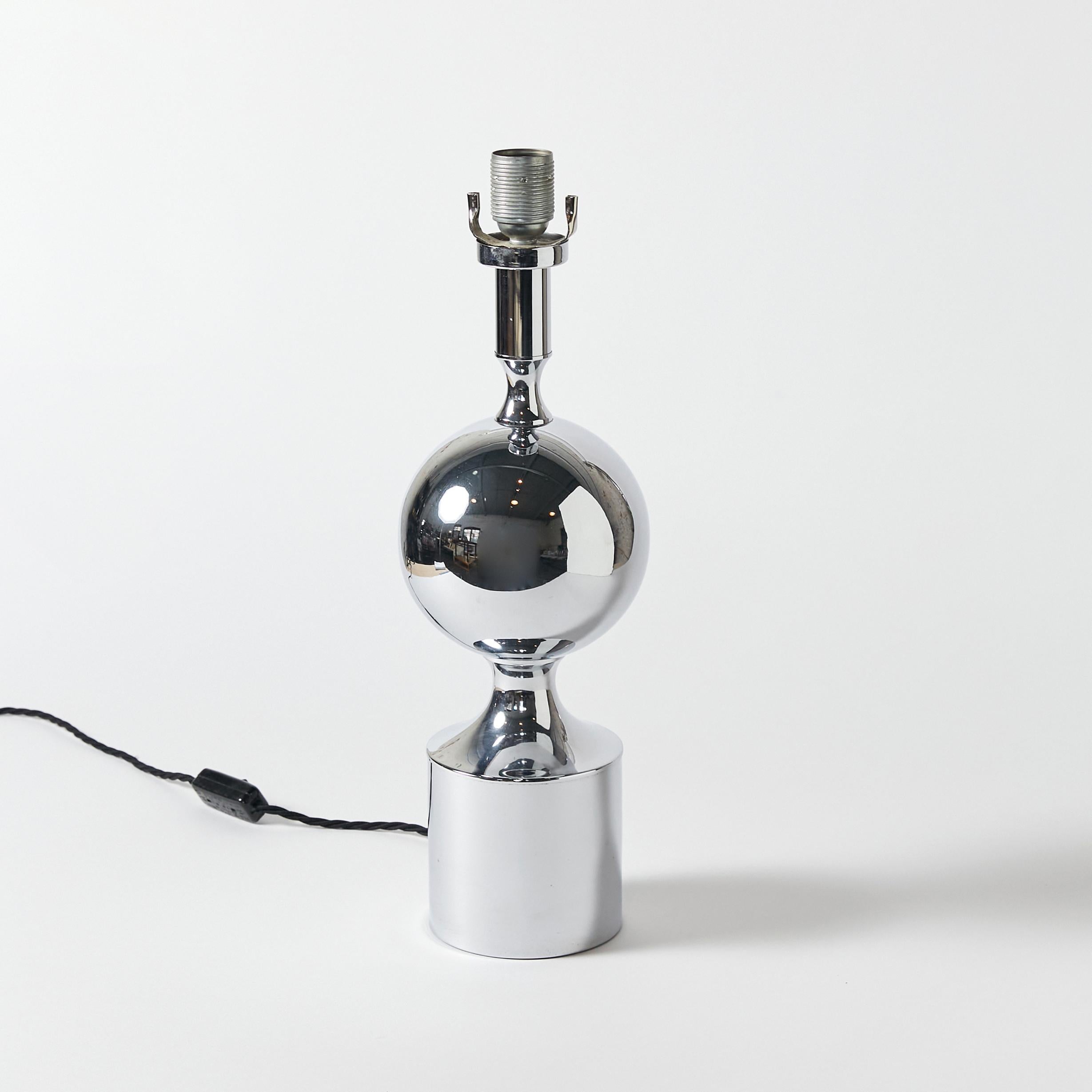 Midcentury French chromed table lamp in the manner of Maison Barbier. A cylindrical base that holds a sphere that ends in a neck with a lamp socket and harp holder.
This item has been rewired with new hardware and braided cloth cord. This lamp does
