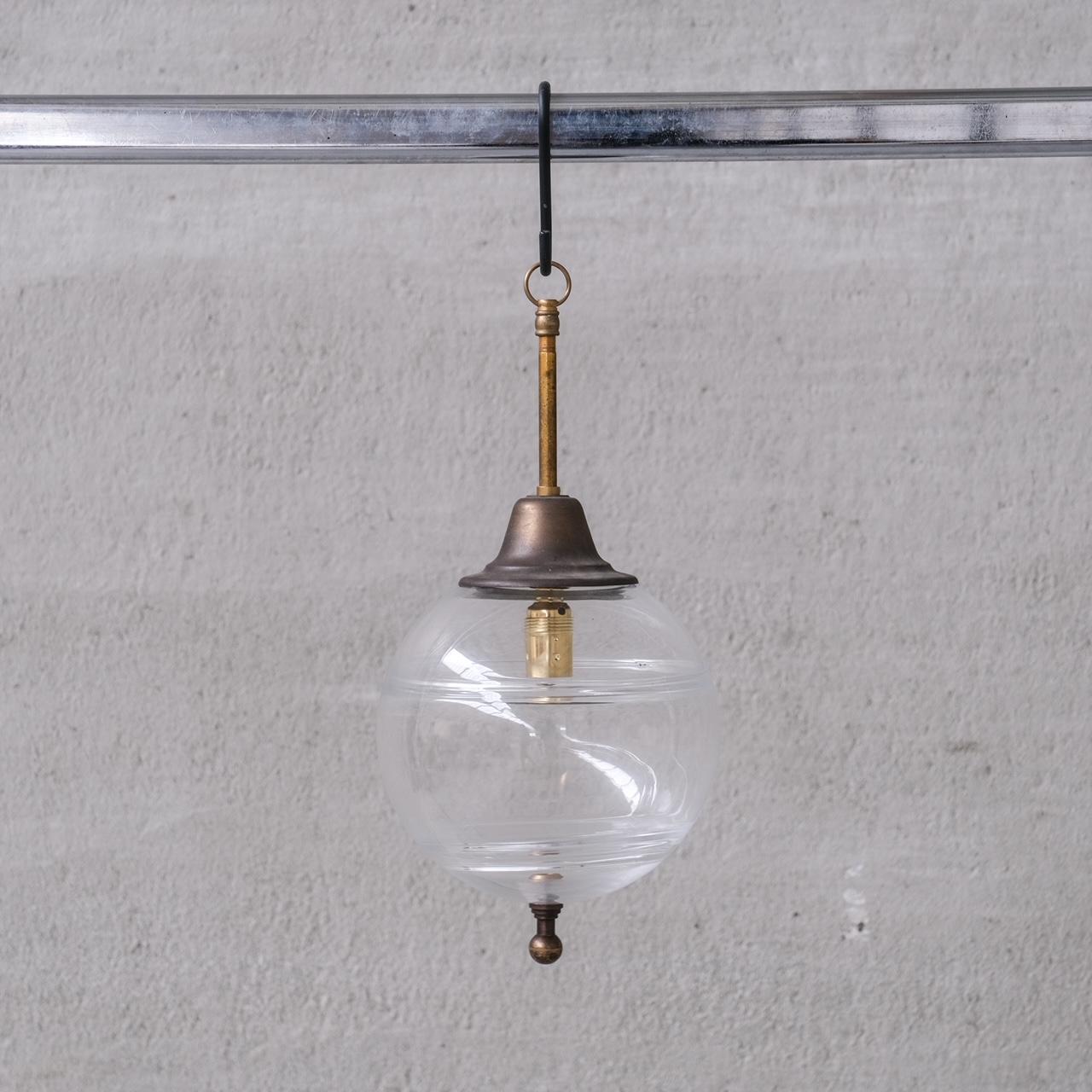 A brass and clear glass pendant light.

Brass finial to base.

Naturally patinated.

Holland, c1950s.

No chain or ceiling rose was retained, we can recommend where to source.

Good vintage condition, some scuffs and wear commensurate with