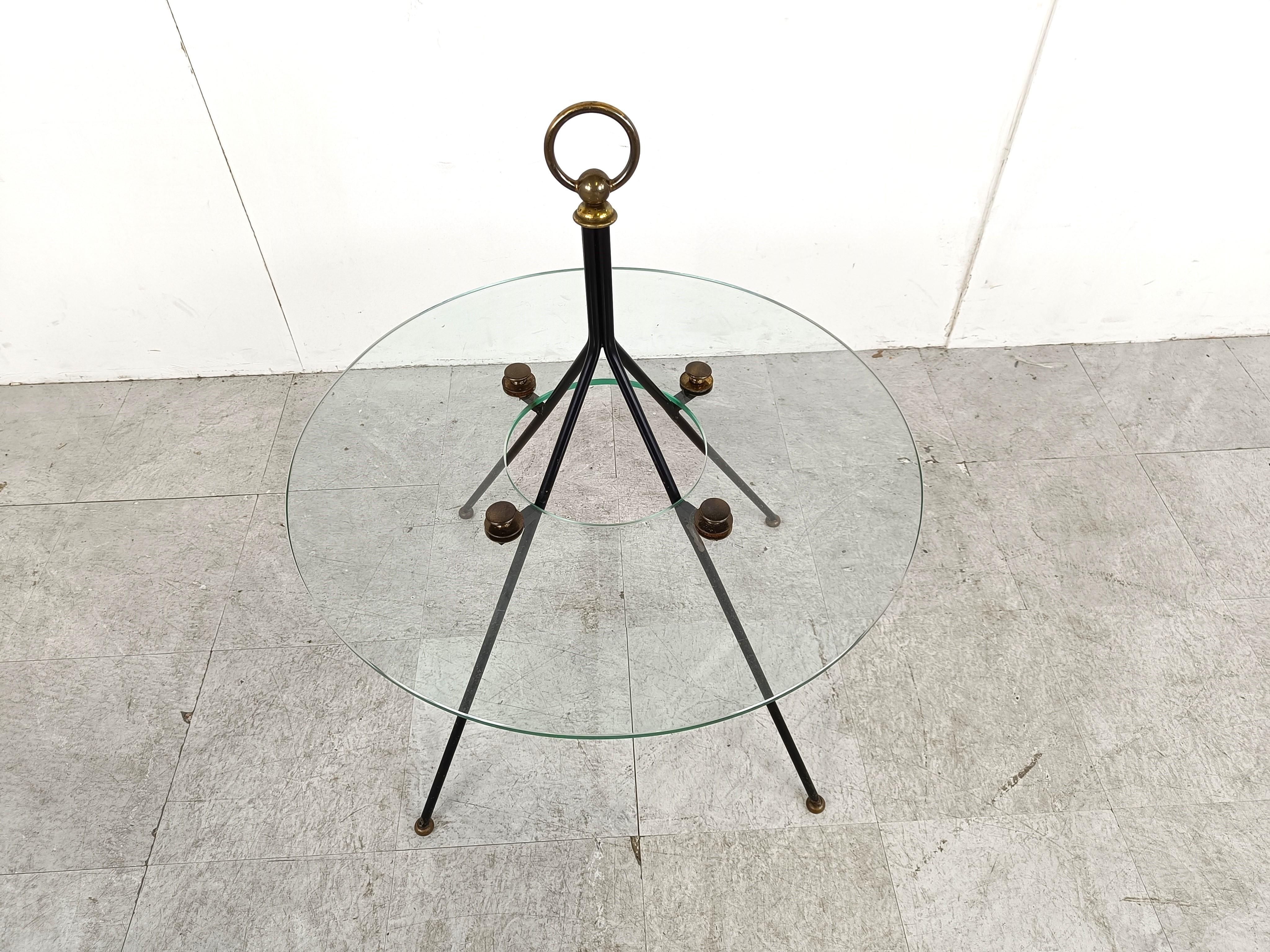 Very rare mid century modern coffee table by Claude Delor.

The coffee table is made out of a black steel base and brass hardware and a round glass table top. 

Very good condition.

1950s - France

Dimensions:
Height: 80cm/31.49