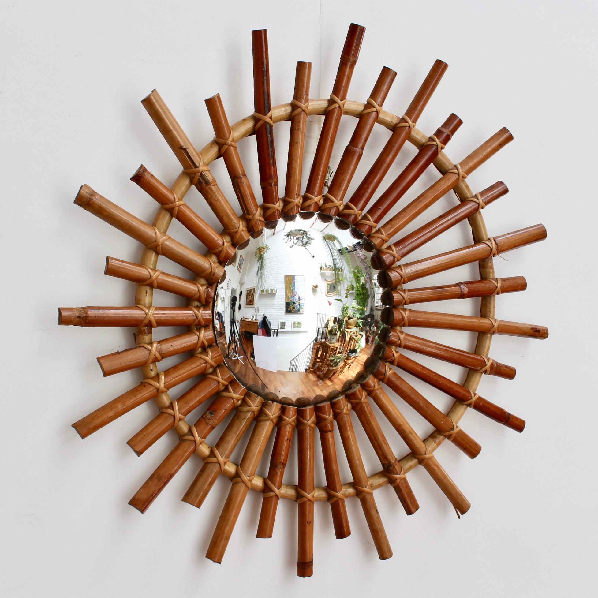 Midcentury French convex sunburst bamboo mirror, circa 1960s. A real find and unique piece, this bamboo mirror takes its inspiration from the much more intricate gilded French mirrors of the 17th and 18th centuries. The convex glass is enclosed by