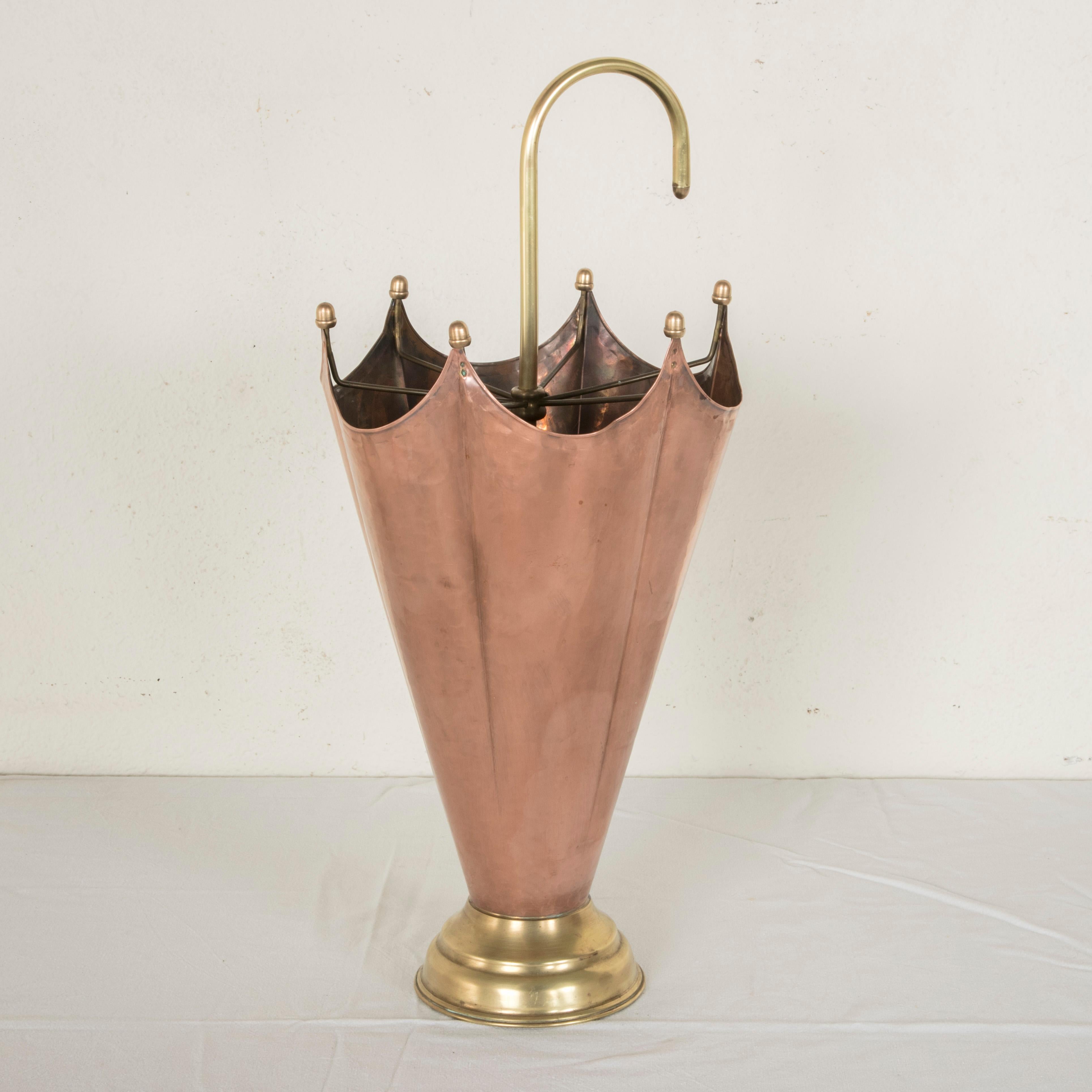 This midcentury copper and brass umbrella stand takes the form of an open umbrella resting on a brass footed base. Found in Normandy, France, this piece will add charm as well as function to any entryway. Base measures 6.25 inches in diameter, circa