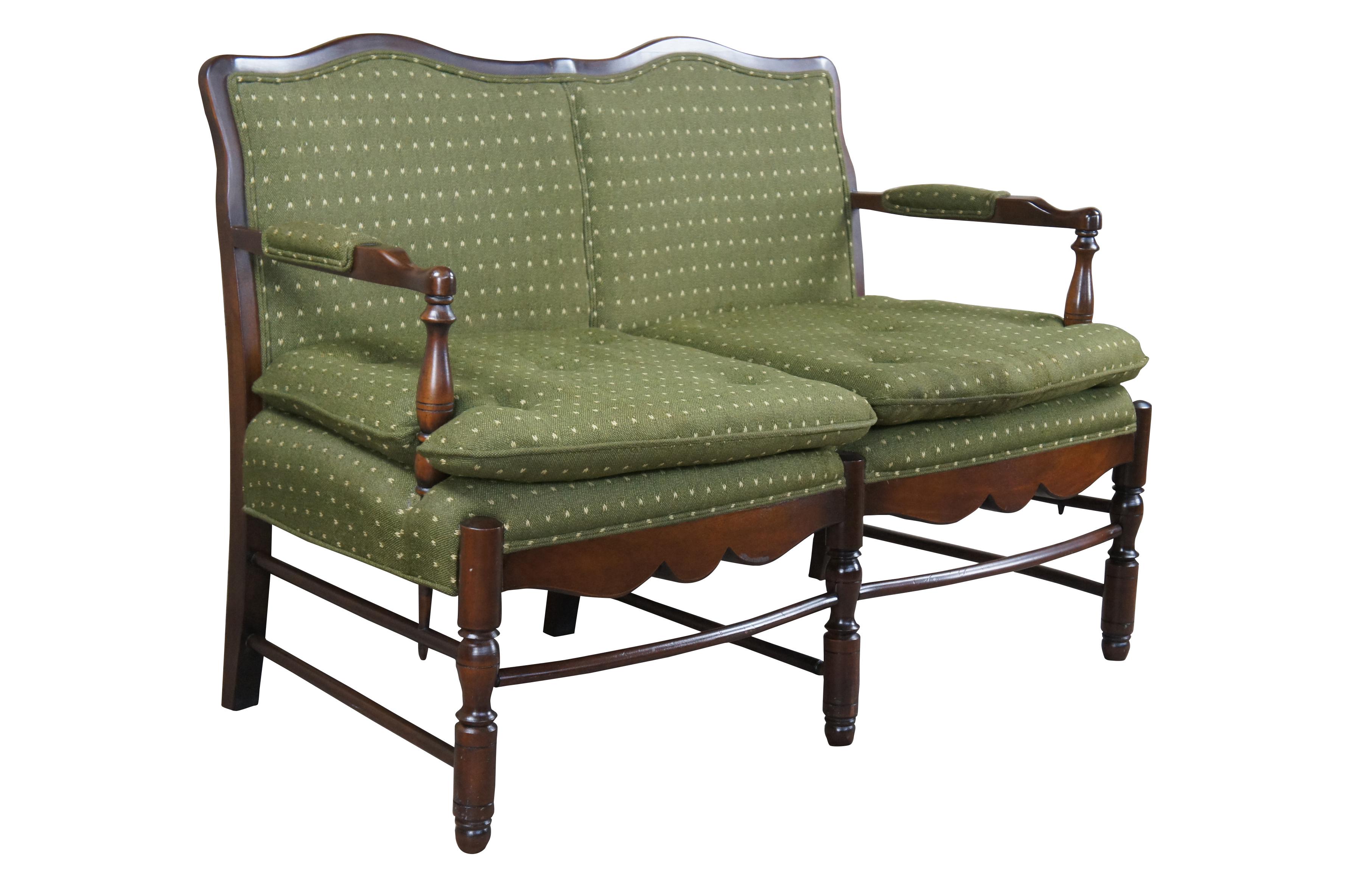 Vintage Country French ladderback settee, circa 1970s.  Features an oak frame with serpentine back, padded arms and skirt.  Upholstered in a green speckled fabric with two tufted removable cushions.

Dimensions:
28